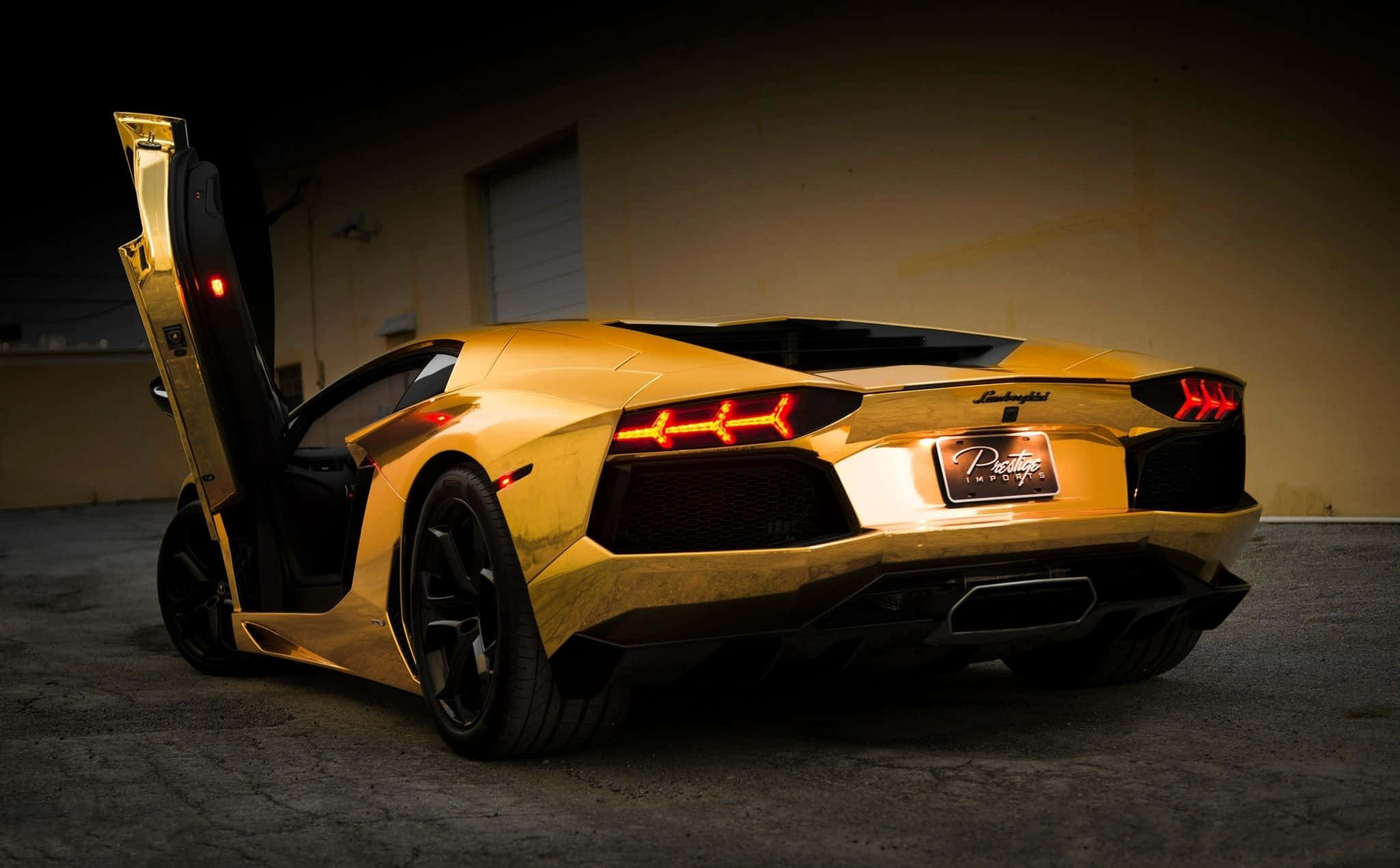 Cool Lamborghini 桌布 壁紙 — 金色藍寶堅尼，剪刀門打開，紅色尾燈在昏暗的車庫牆壁前發光。