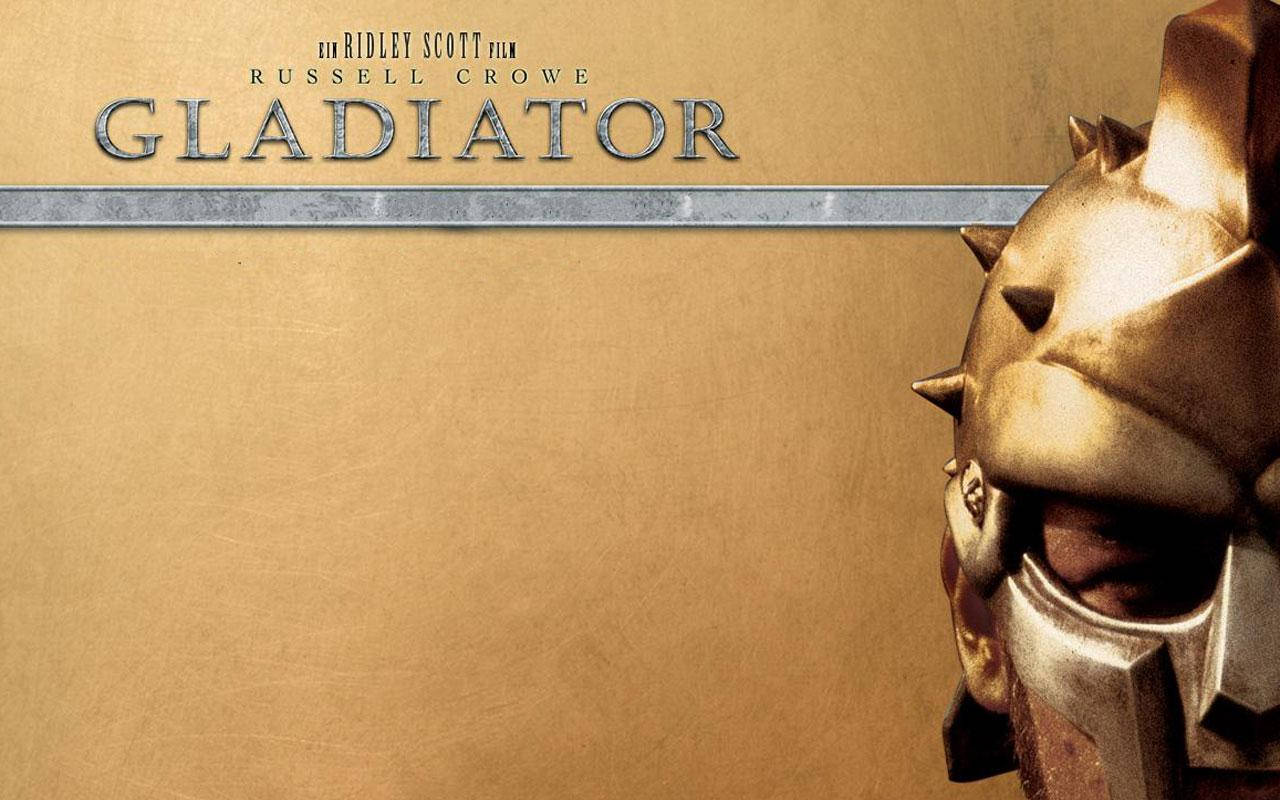 Gladiator 桌布 壁紙 — 金色角鬥士頭盔特寫，帶有尖刺，背景為紋理金色，並顯示電影標題。
