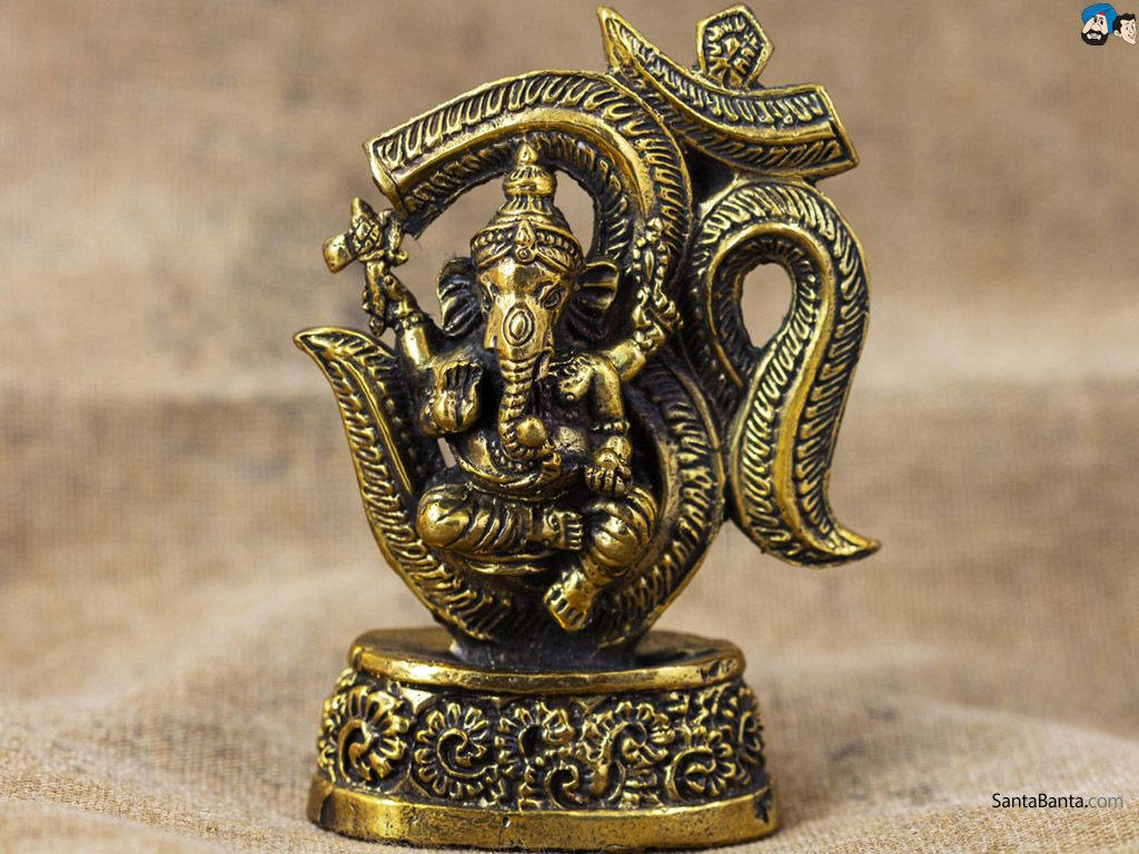 Ganesh 桌布 壁紙 — 金色象神雕像，細節精緻，置於華麗底座上，背景為有紋理的米色布料。