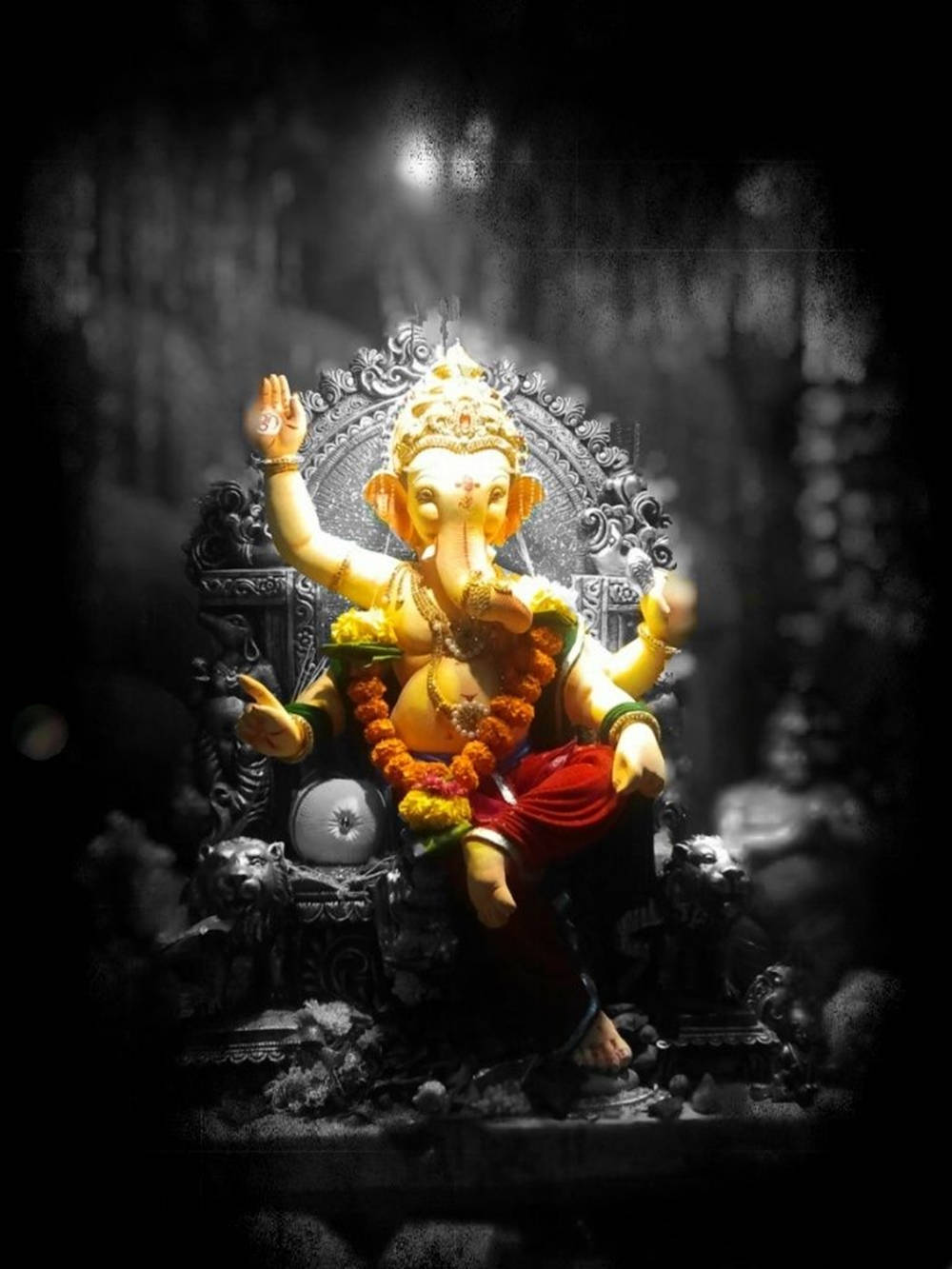 hindu iPhone 桌布 壁紙 — 金色象神雕像坐在華麗的寶座上，在聚光燈下，背景黑暗模糊。