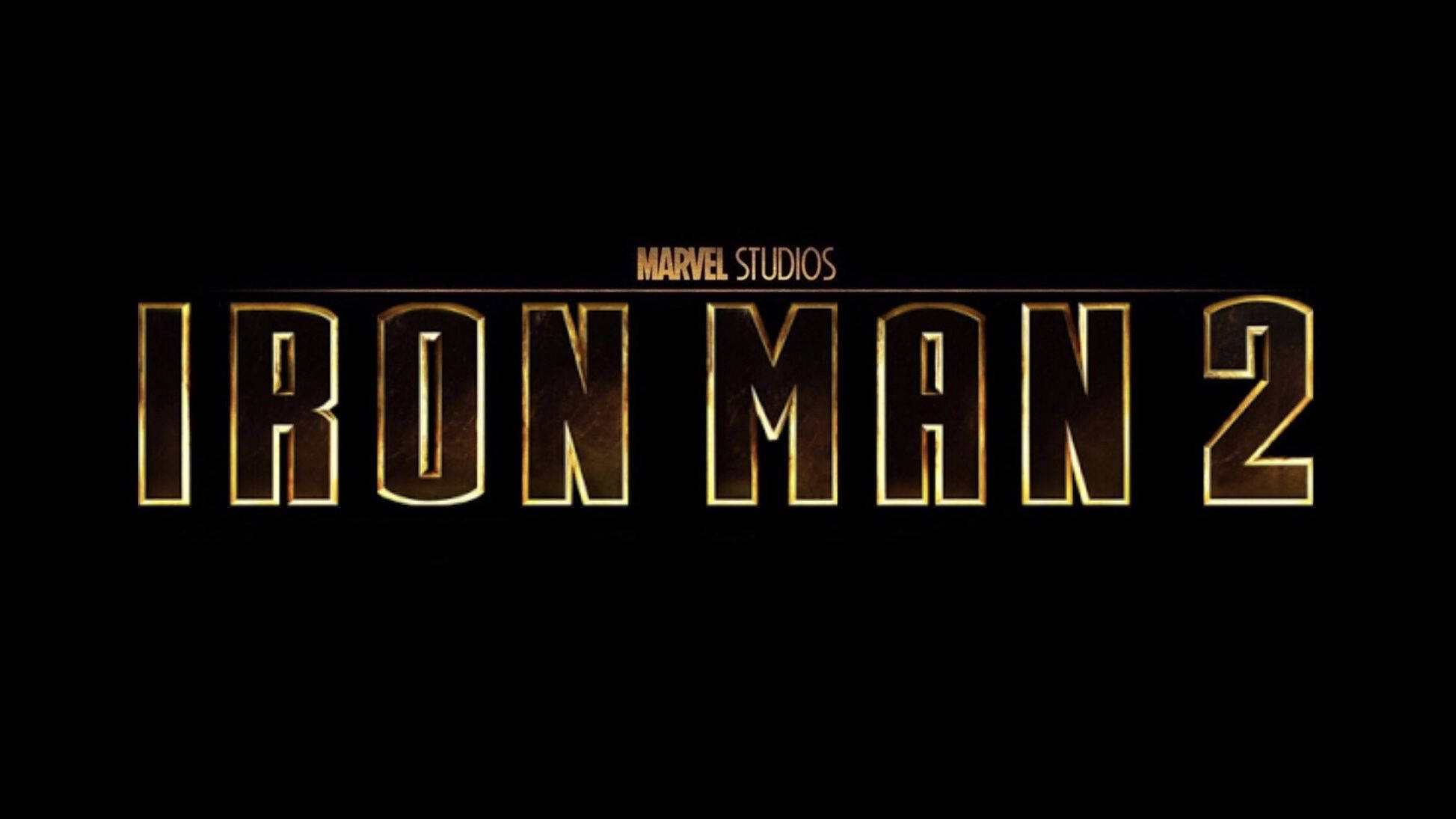 Iron Man Logo 桌布 壁紙 — 金色金屬質感的「鋼鐵人2」標題標誌在純黑背景上發光，上方有「Marvel Studios」字樣。
