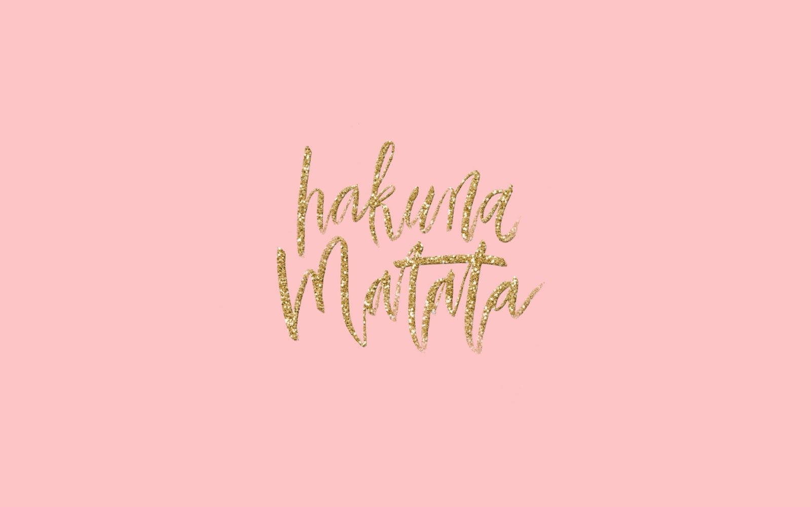 macbook pro 桌布 壁紙 — 金色閃亮的 'hakuna matata' 字體漂浮在柔和的粉紅色背景上，沒有其他元素。