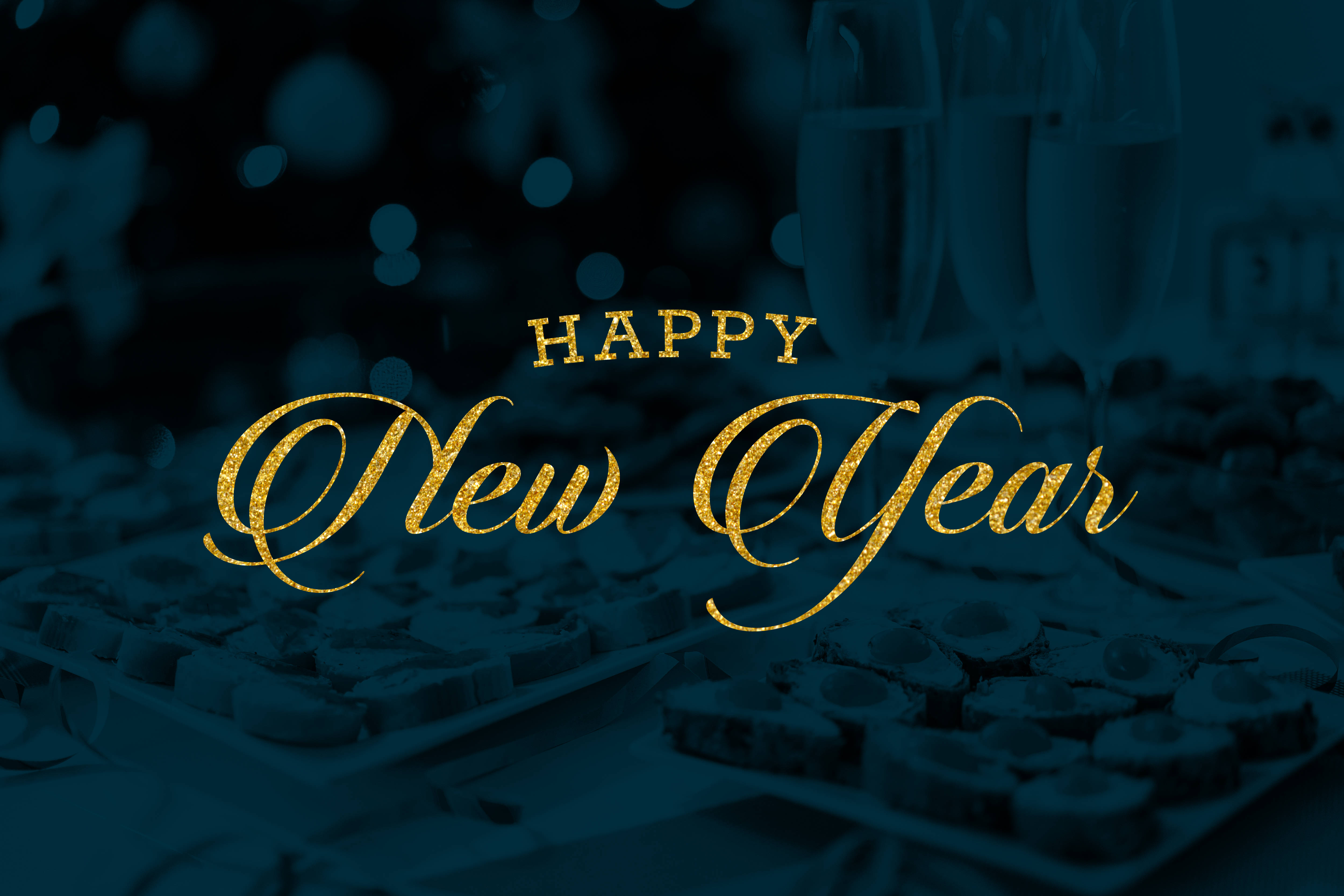 Greetings 桌布 壁紙 — 金色閃亮的「Happy New Year」文字在深藍綠色背景上，於模糊的香檳杯和巧克力上方閃耀。