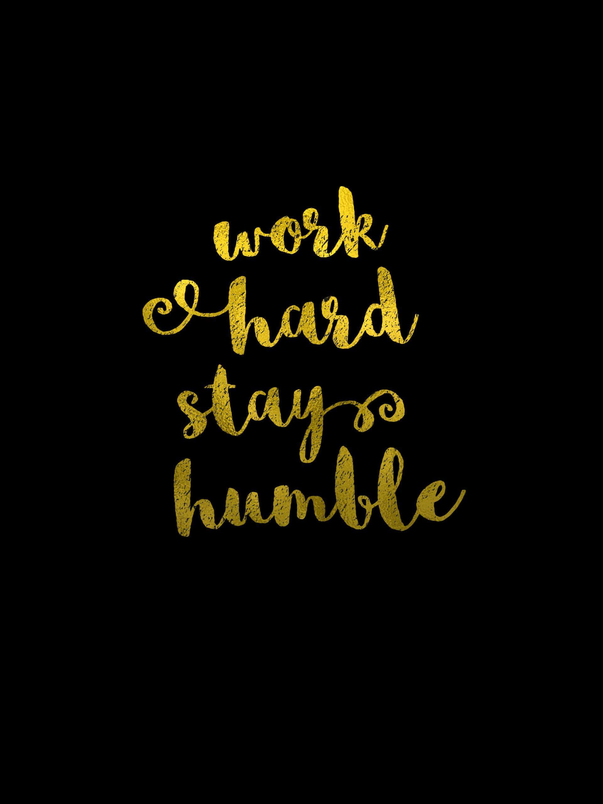 激勵 桌布 壁紙 — 金色閃亮草書文字「work hard stay humble」居中於純黑色背景上。