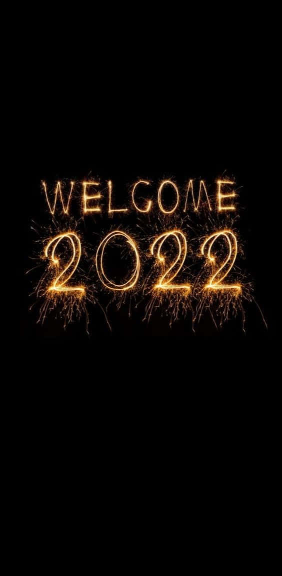新年快樂 桌布 壁紙 — 金色閃爍的文字顯示歡迎2022，背景為黑色，並有飛舞的火花。