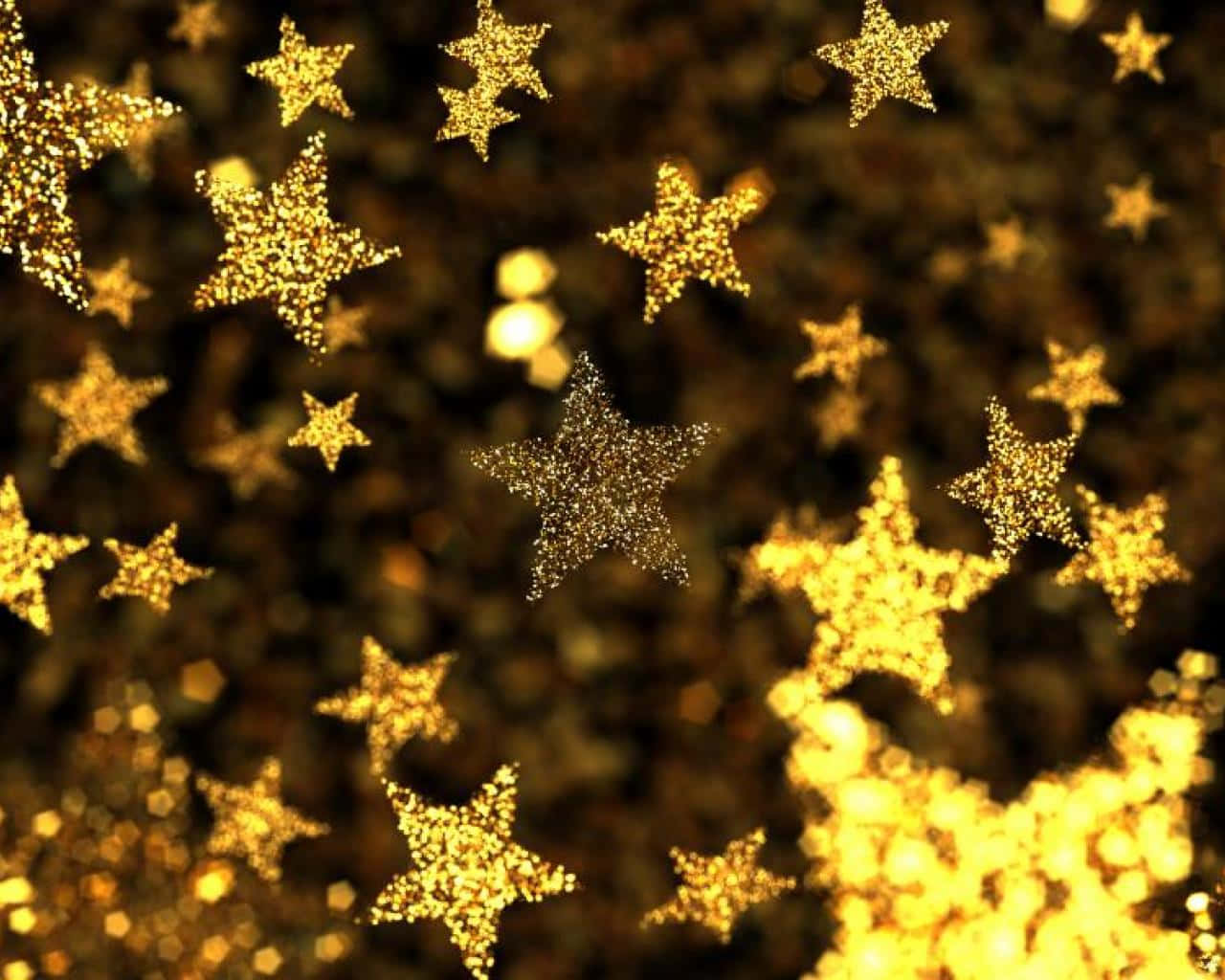 Gold Stars 桌布 壁紙 — 金色閃爍的星星在溫暖的散景背景上漂浮，營造出節日魔幻的光芒。