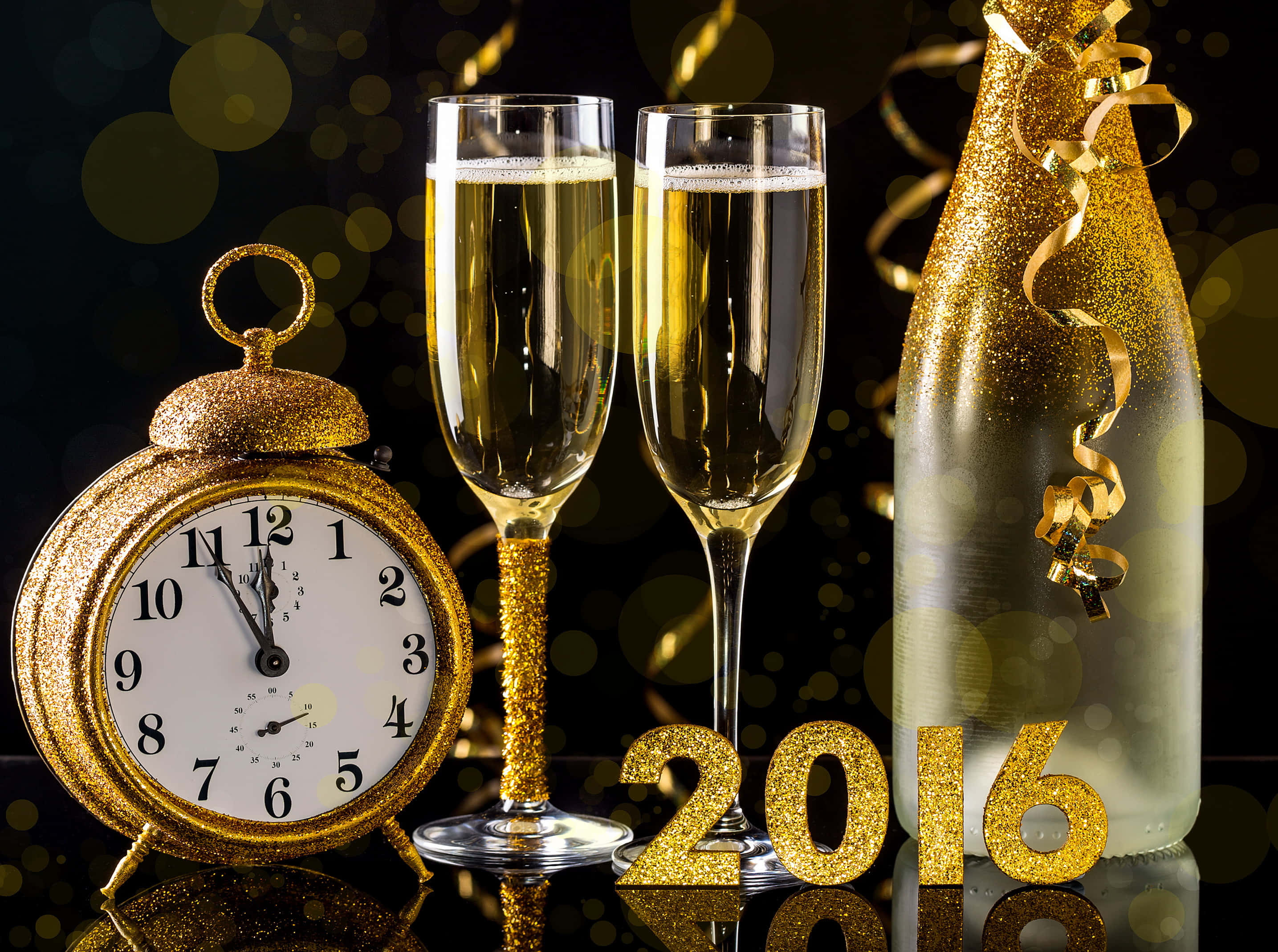 Champagne 桌布 壁紙 — 金色閃粉時鐘、香檳杯和酒瓶在閃爍的散景背景下慶祝2016年新年。