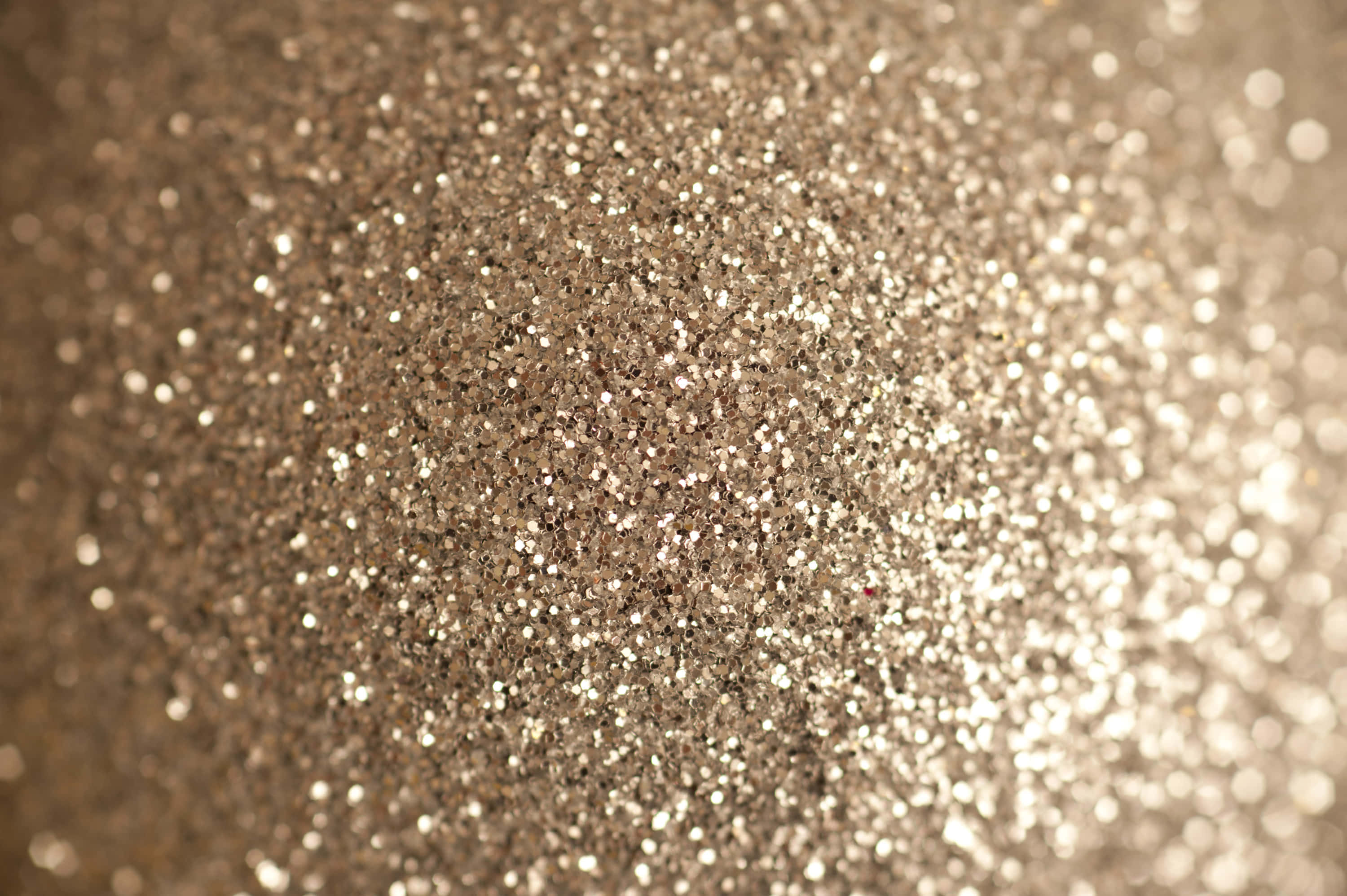 High Resolution Gold Glitter 桌布 壁紙 — 金色閃粉的特寫，帶有柔和散景高光以及從密集到稀疏閃爍的漸變。