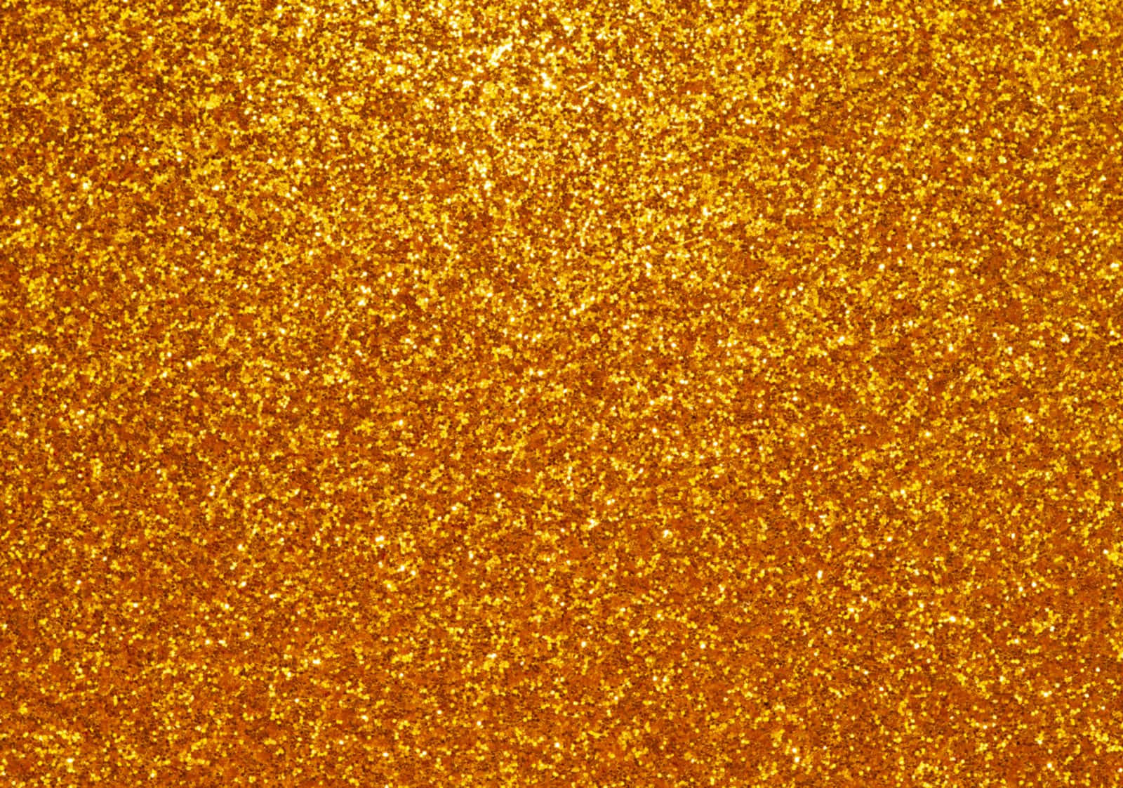 High Resolution Gold 桌布 壁紙 — 金色閃粉的特寫，閃爍的粒子在整個畫面中捕捉光線。