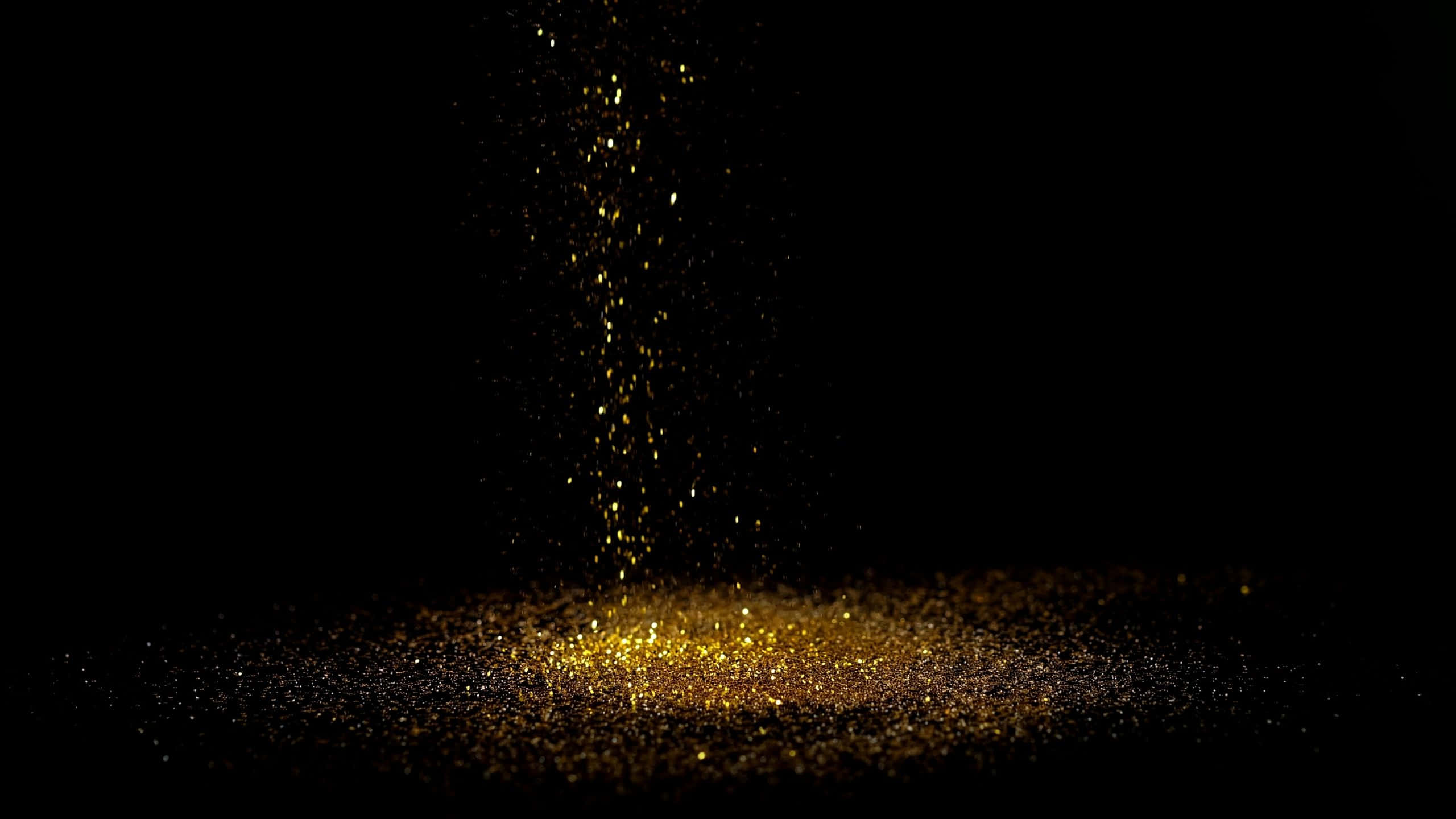 Black And Gold Glitter 桌布 壁紙 — 金色閃粉粒子在純黑色背景上層疊散落，營造出閃爍的動態效果。