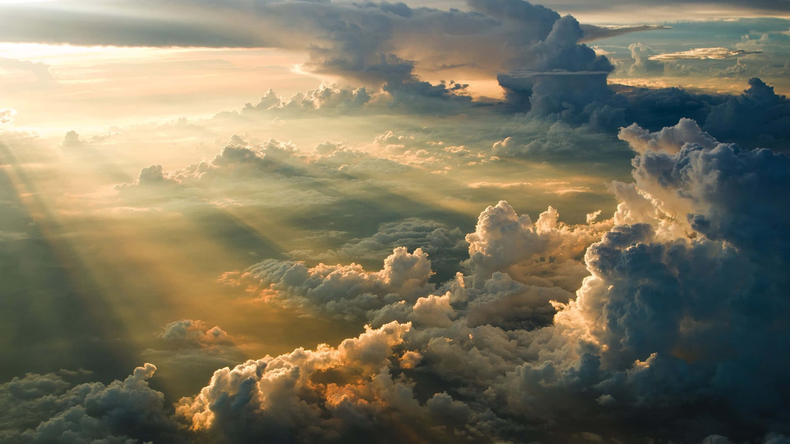 Cloud 桌布 壁紙 — 金色陽光穿透戲劇性的雲層，呈現出令人嘆為觀止的日出或日落空中景觀。