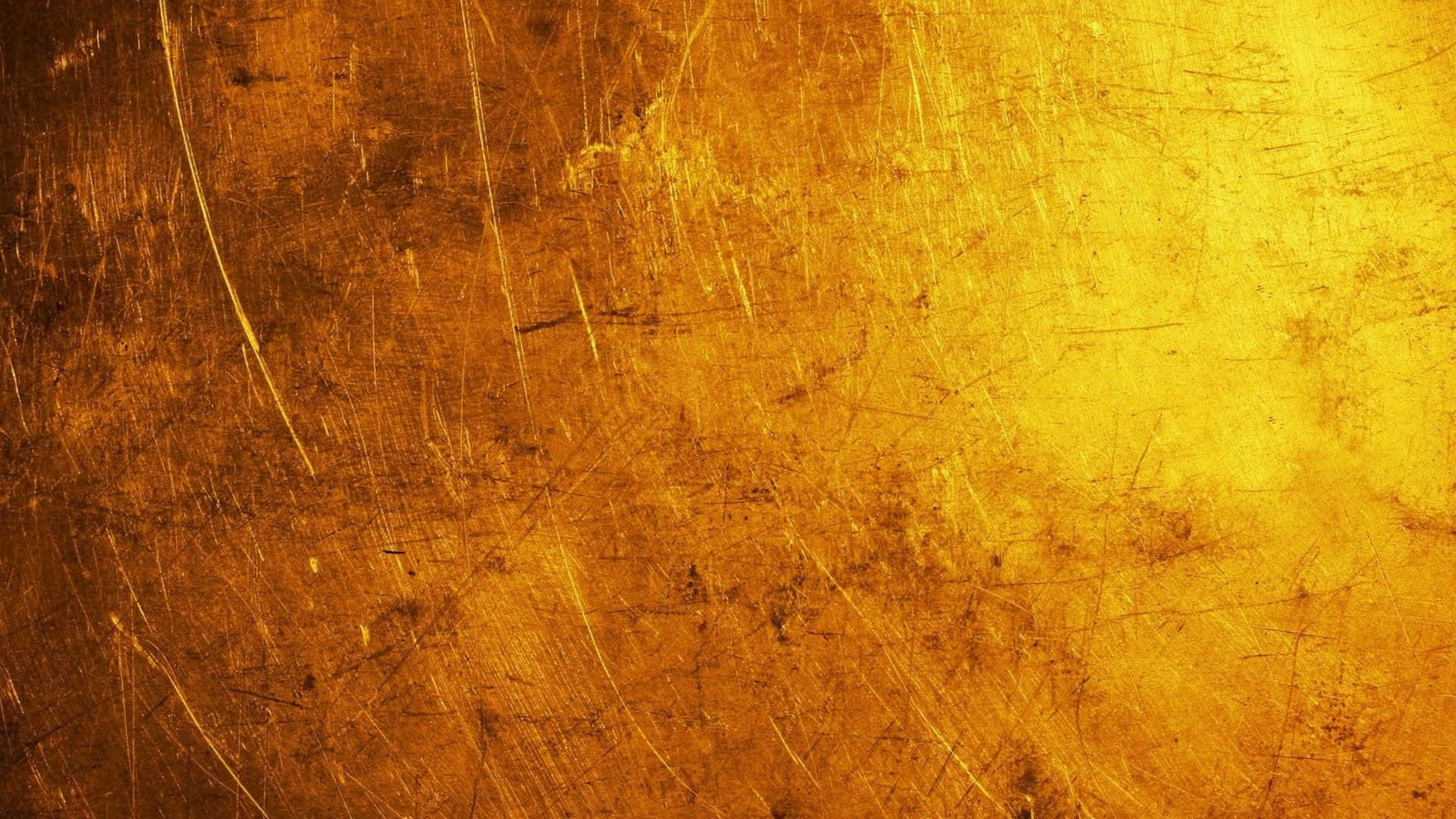 Gold Texture 桌布 壁紙 — 金色風化表面的特寫，帶有刮痕和銅綠，溫暖地發光。