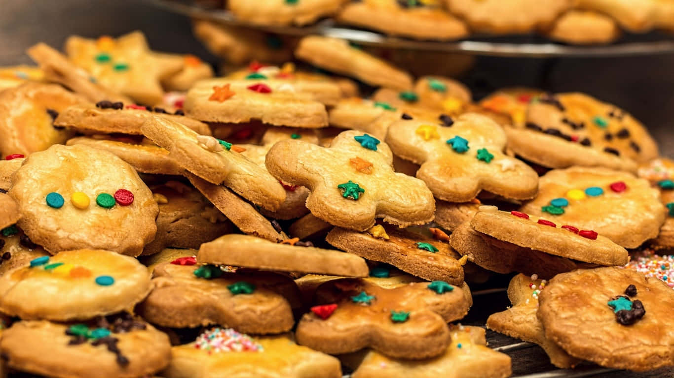 1366x768 Cookies 桌布 壁紙 — 金色餅乾的特寫，形狀為星星和花朵，裝飾著彩色糖果和糖霜。