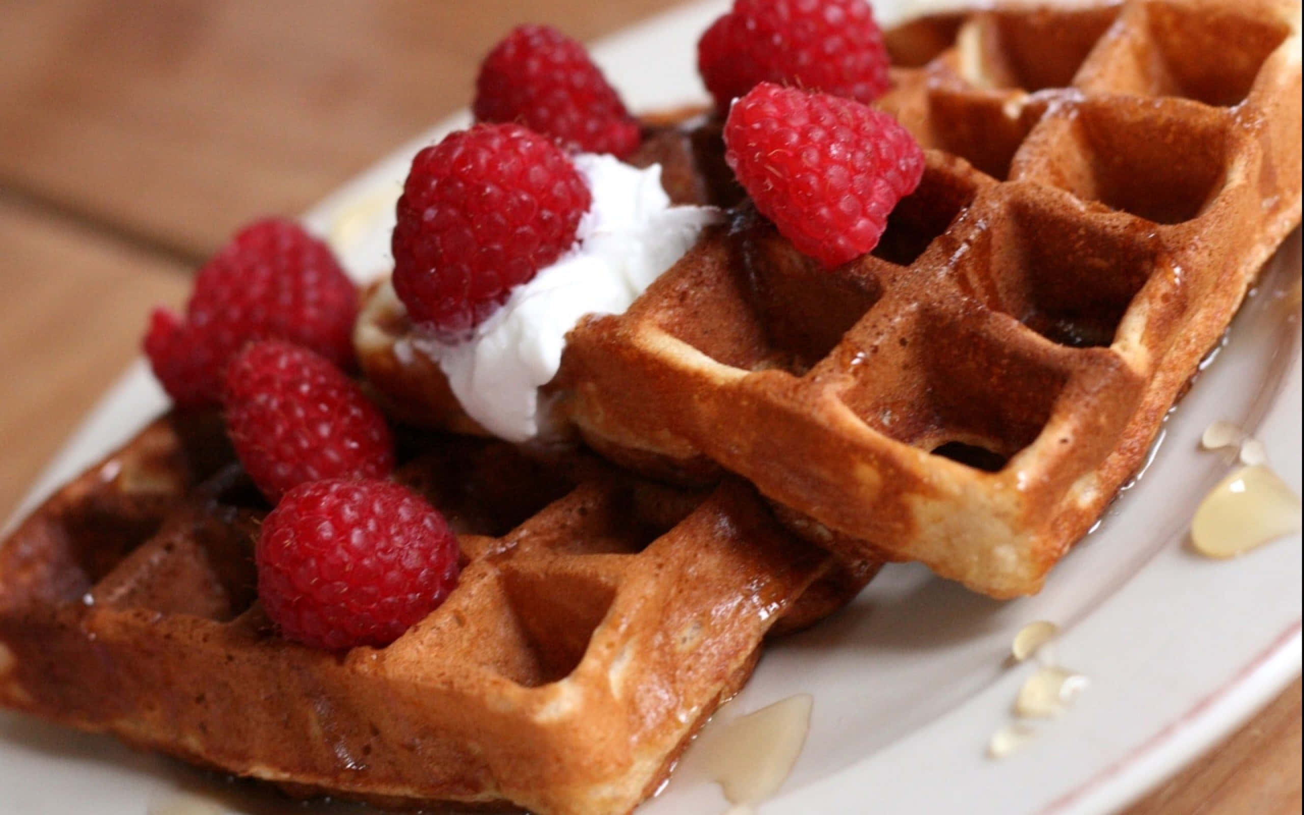 Waffle 桌布 壁紙 — 金色鬆餅搭配新鮮覆盆子、鮮奶油和蜂蜜，放在白色盤子上。