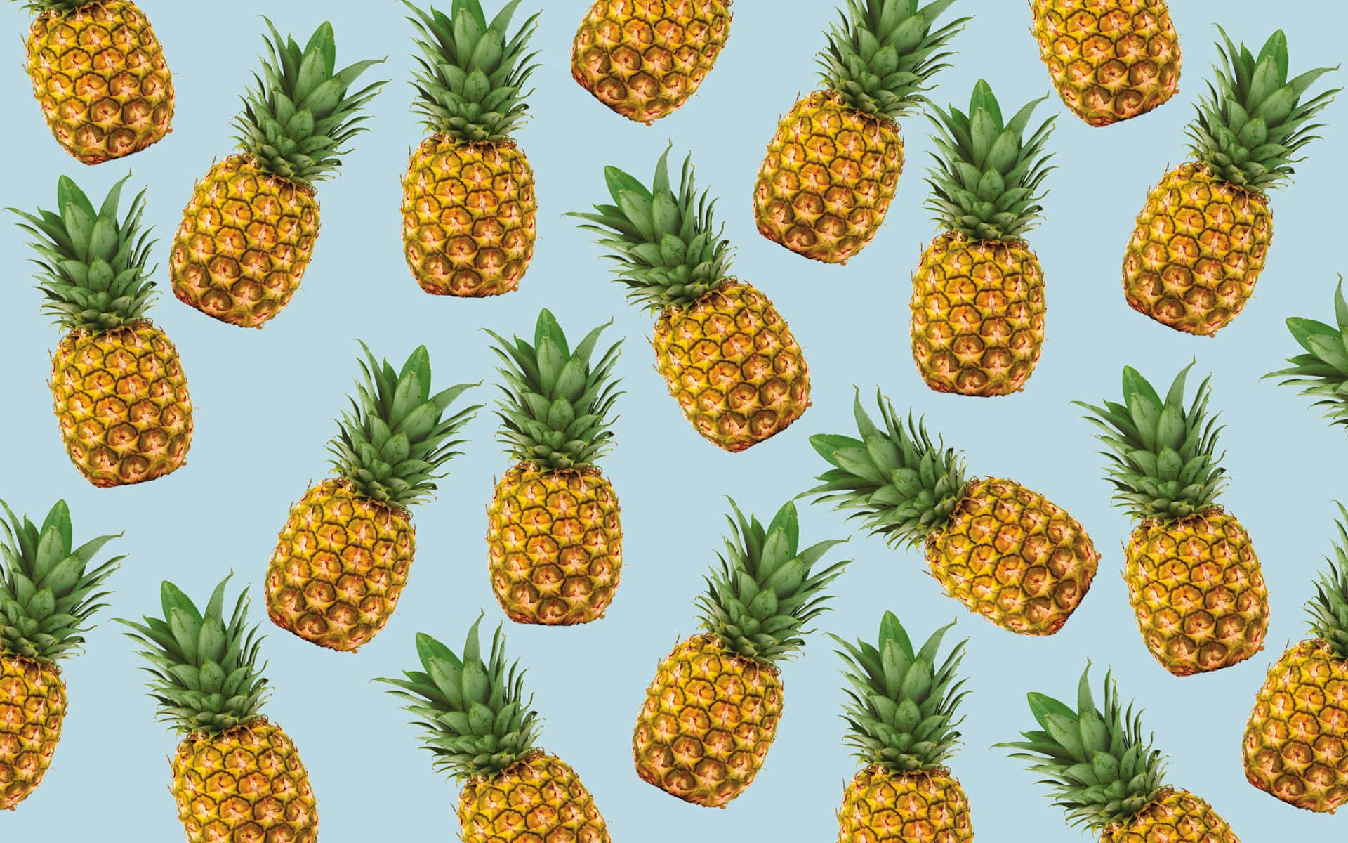 Pineapple Desktop 桌布 壁紙 — 金色鳳梨搭配綠色皇冠在柔和藍色背景上重複形成鮮豔圖案。