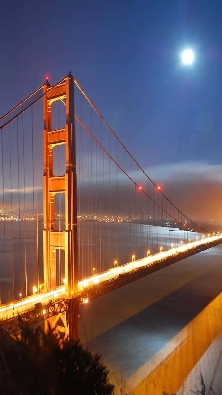 Android San Francisco 桌布 壁紙 — 金門大橋在明亮的滿月下夜間亮燈，遠處城市燈光閃爍。