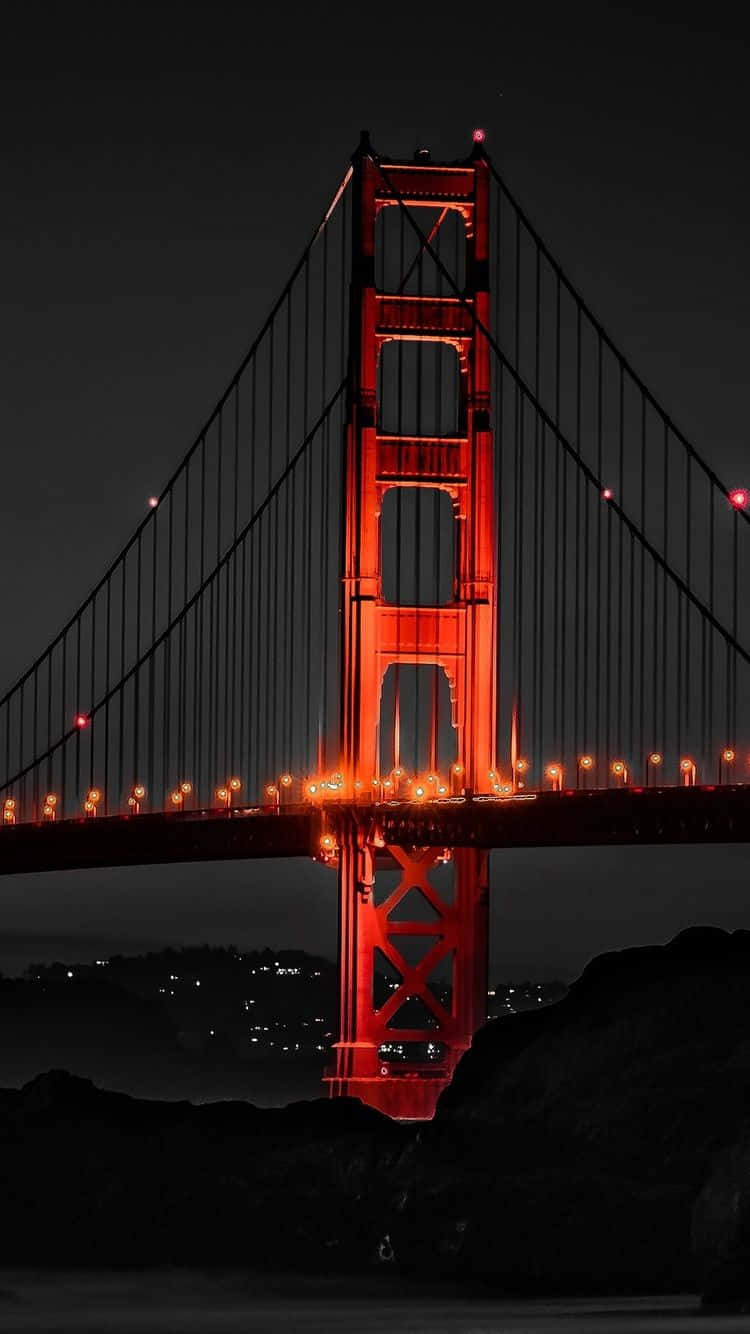 Android San Francisco 桌布 壁紙 — 金門大橋在漆黑的夜空下閃耀著火紅的光芒，下方城市燈光閃爍。