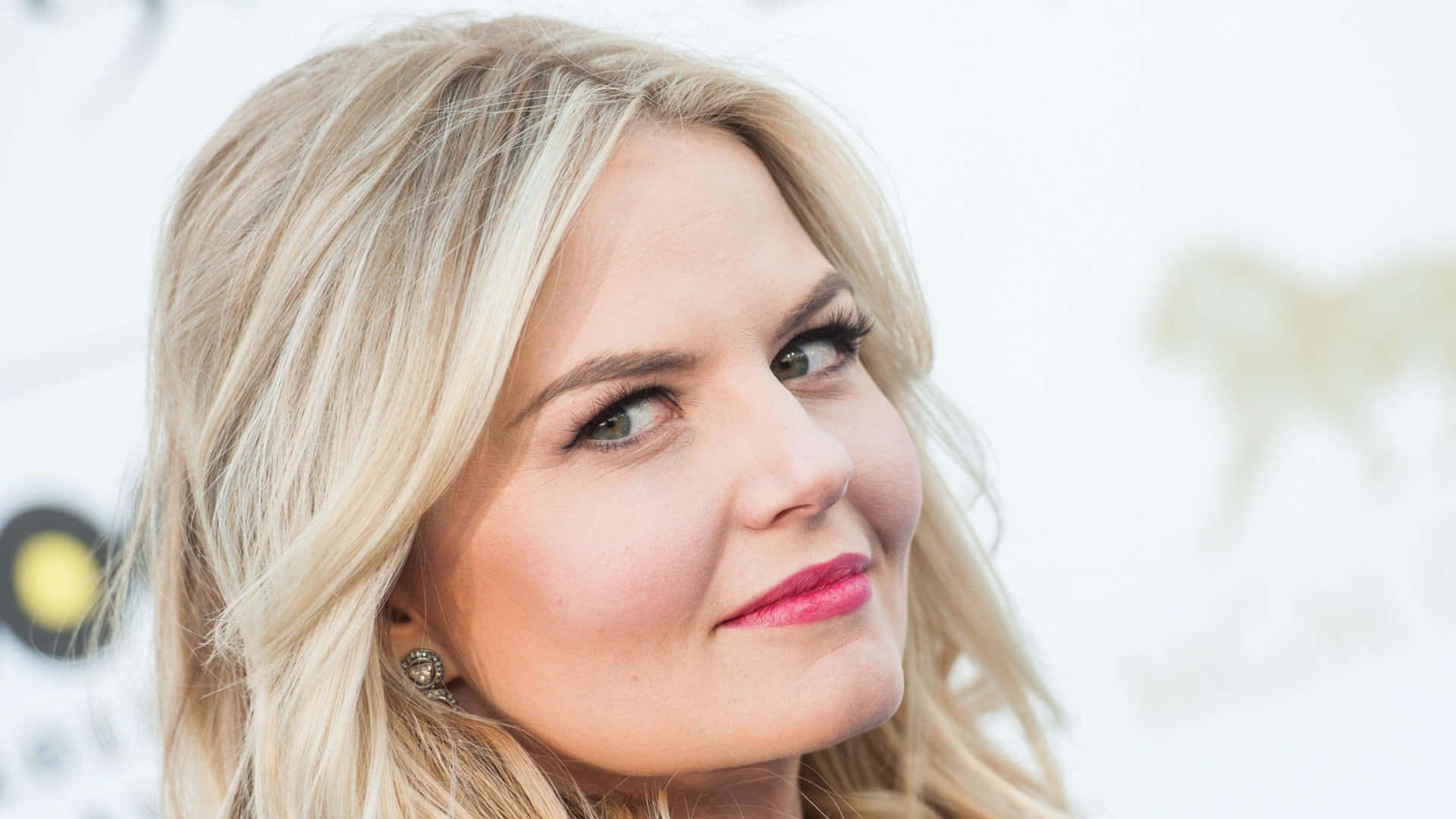 jennifer morrison 桌布 壁紙 — 金髮女性特寫肖像，塗粉色唇膏，綠色眼睛，在明亮的白色背景前溫柔微笑。