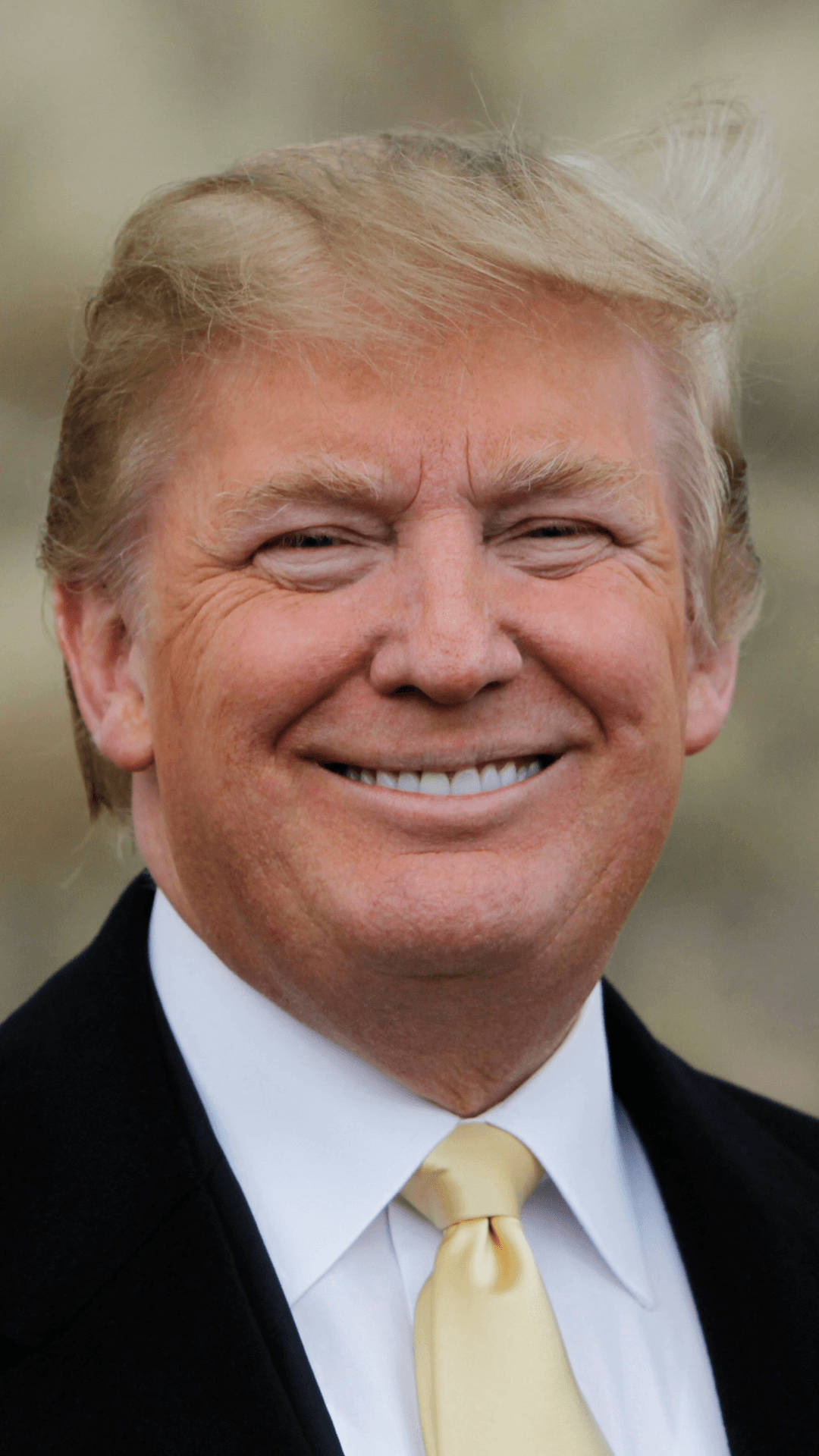 donald trump 桌布 壁紙 — 金髮微笑男士穿著黑色西裝和金色領帶的特寫肖像。
