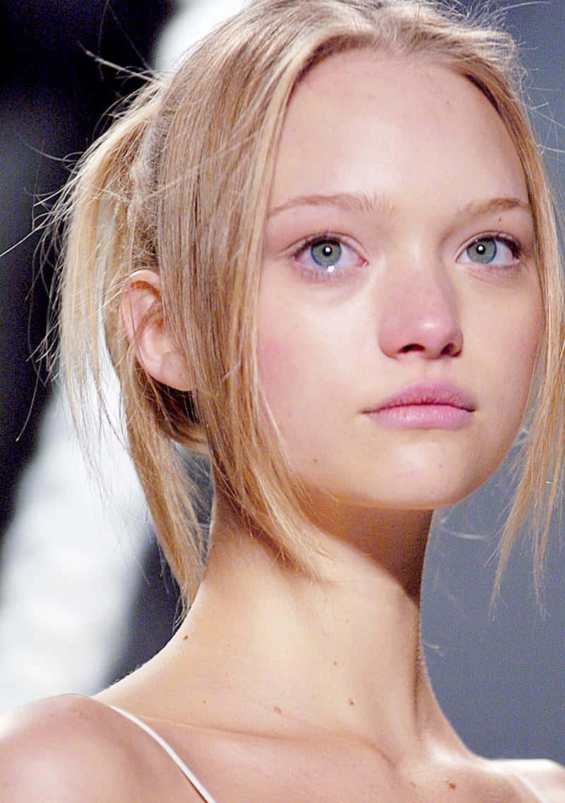 Gemma Ward 桌布 壁紙 — 金髮模特兒擁有引人注目的藍色眼睛和柔和妝容，在時裝天橋上走秀的特寫。