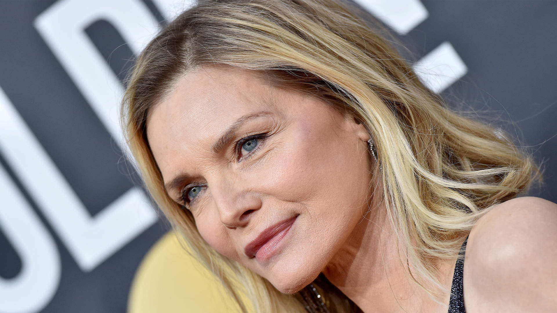 Celebrity 桌布 壁紙 — 金髮藍眼女士在模糊背景標誌的活動中微笑的近距離肖像。