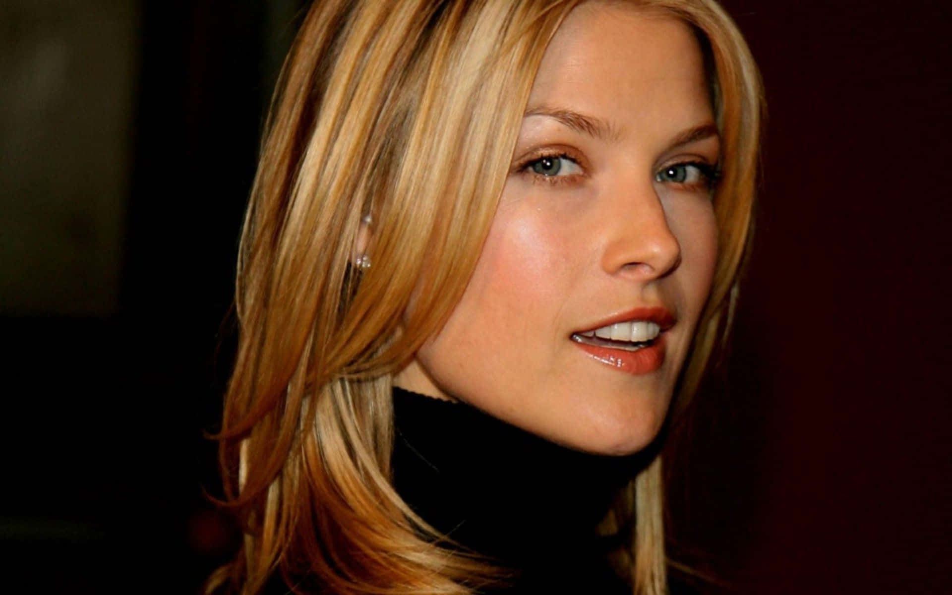 ali larter 桌布 壁紙 — 金髮藍眼女性在深色背景下溫柔微笑的特寫肖像。