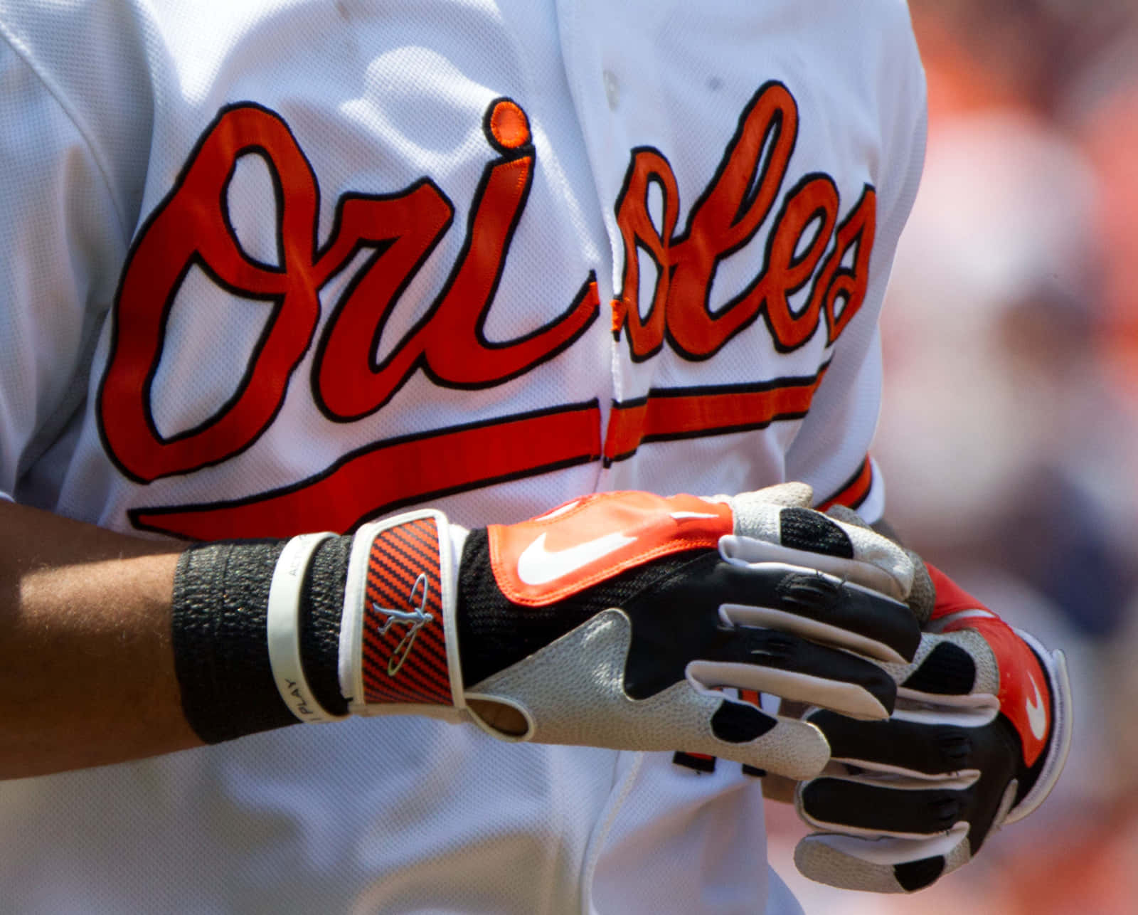 Baseball Gloves 桌布 壁紙 — 金鶯隊制服棒球球員的特寫，橙色和黑色打擊手套合攏在一起。