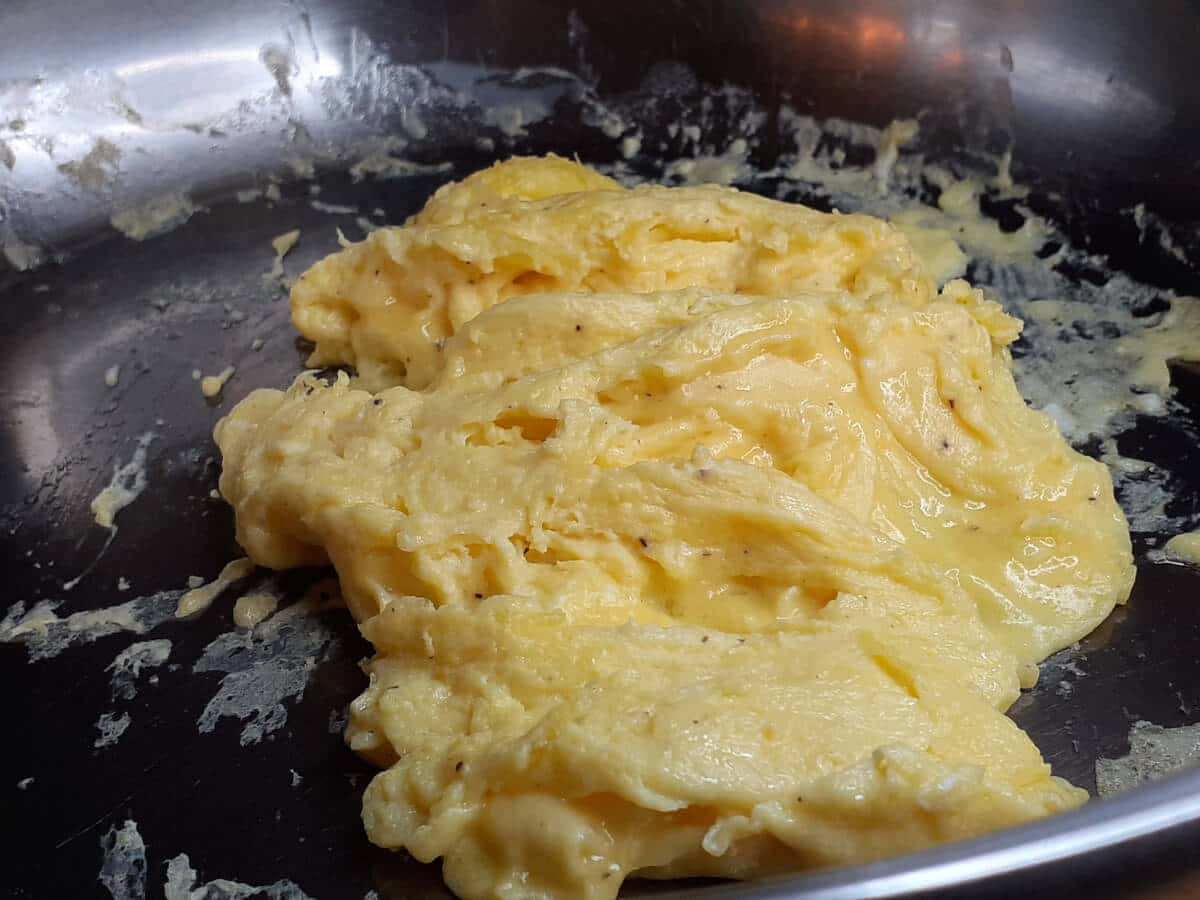 Scrambled Egg 桌布 壁紙 — 金黃色 fluffy 炒蛋配黑胡椒，在一個用得很舊的不鏽鋼煎鍋中滋滋作響。