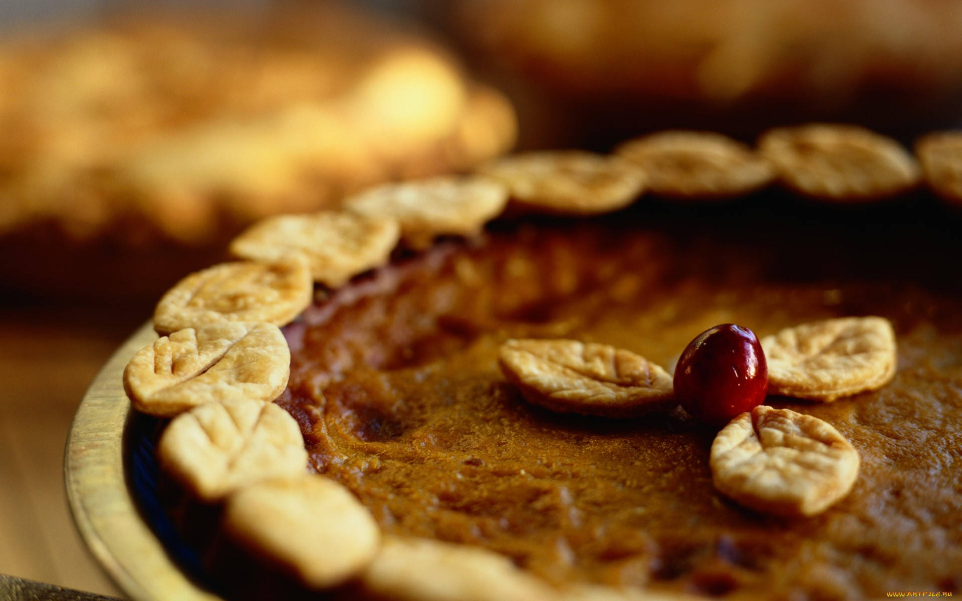 Pie 桌布 壁紙 — 金黃色南瓜派的特寫，帶有葉形外皮和單個蔓越莓裝飾。