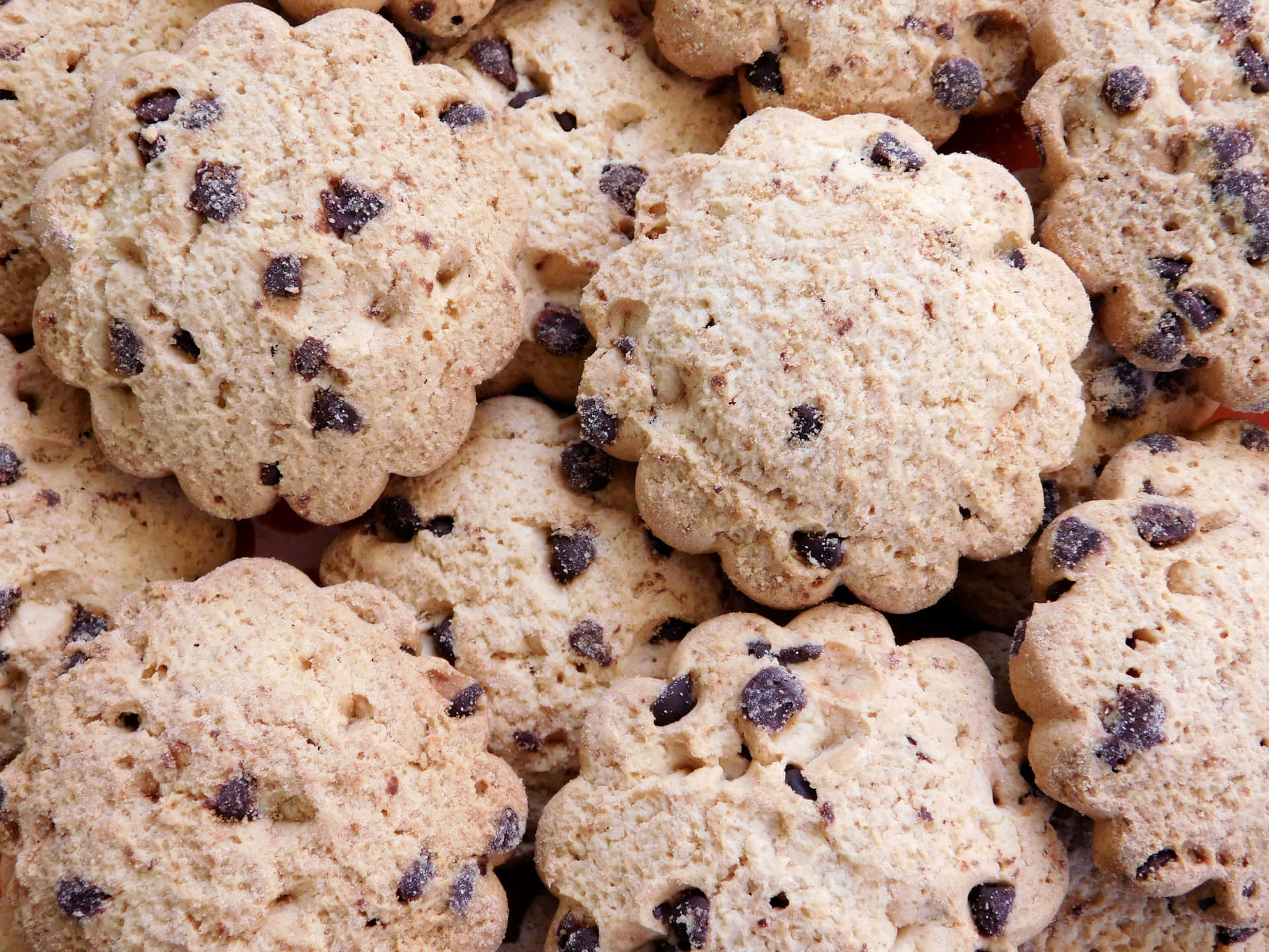 Cookies 壁紙 — 金黃色巧克力曲奇餅邊緣呈扇貝形狀堆疊在一起的近距離特寫。