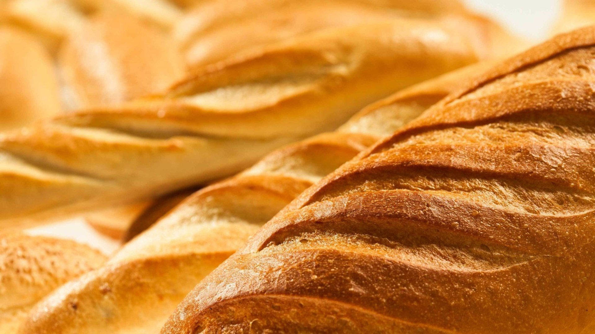 Bread 桌布 壁紙 — 金黃色法式長棍麵包，外皮酥脆，以溫暖誘人的特寫排列。