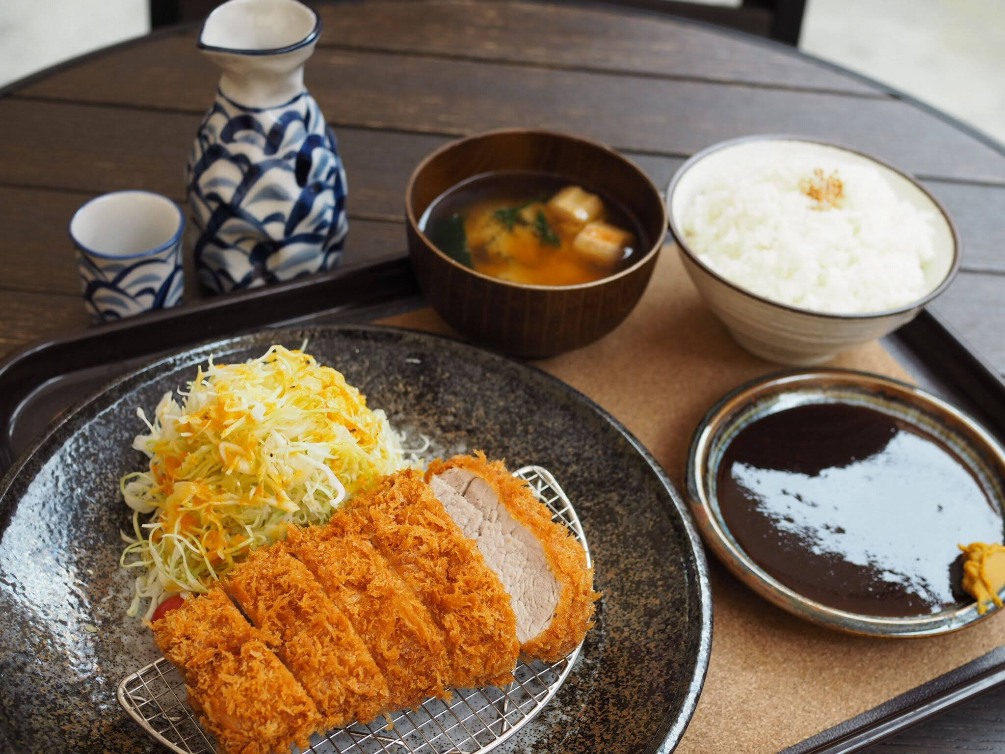 Food Photography 桌布 壁紙 — 金黃色炸豬排搭配高麗菜絲放在托盤上，旁邊有白飯、味噌湯和醬油。