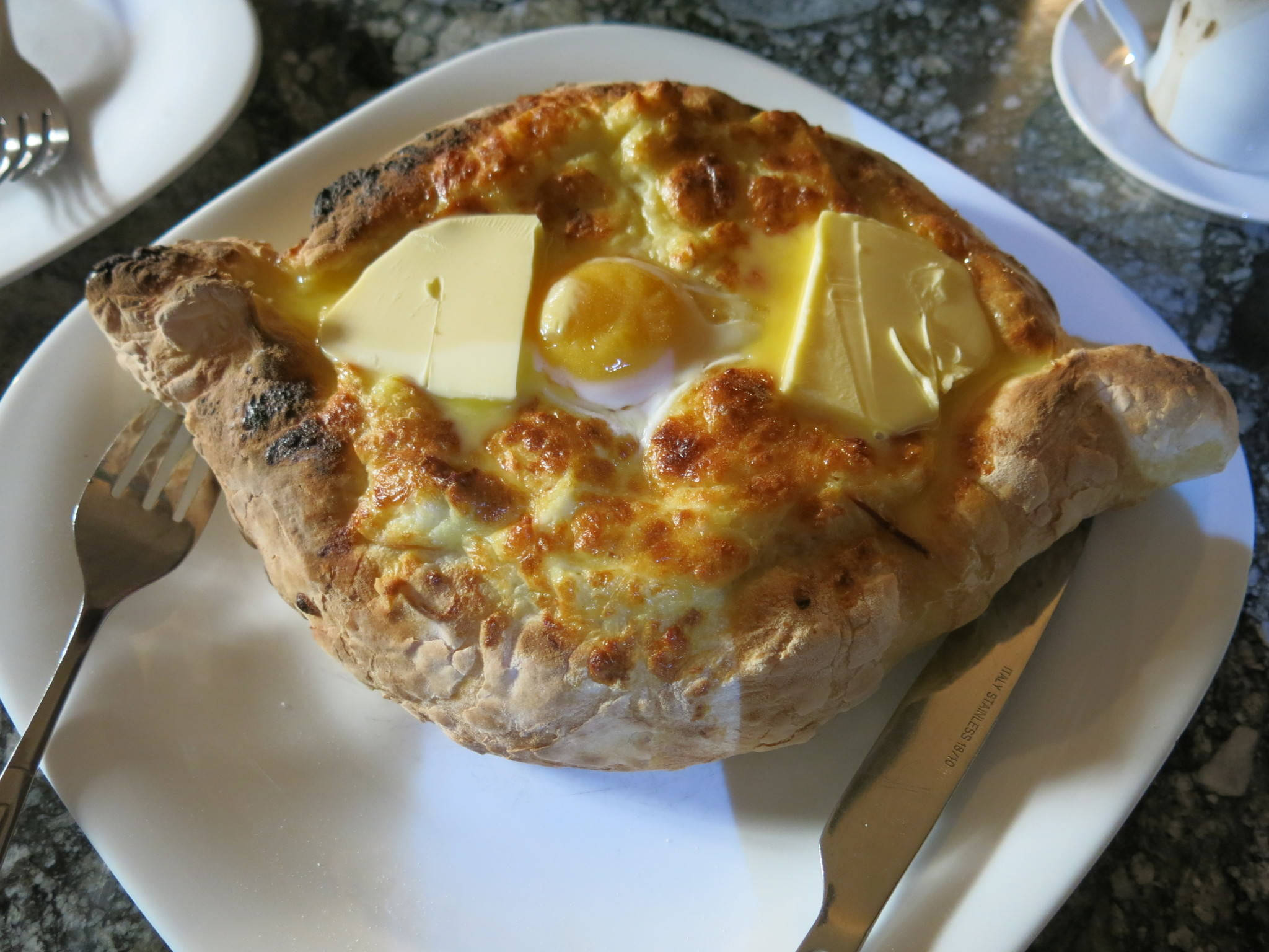 Cheese 桌布 壁紙 — 金黃色烤製菜餚，內有太陽蛋和奶油片，置於香脆麵包碗中。