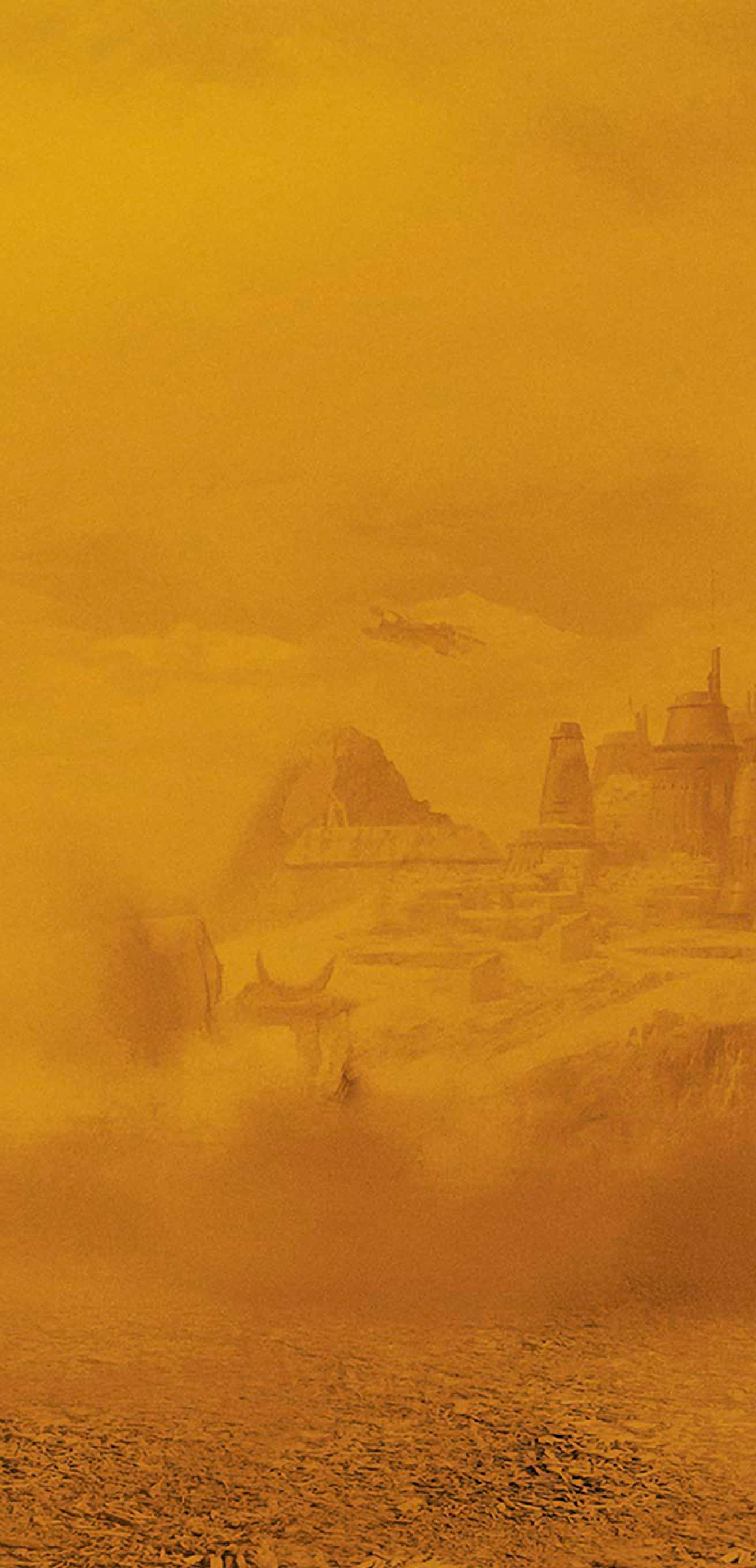 Solo A Star Wars Story 桌布 壁紙 — 金黃色的沙漠景觀，有古代遺跡和一個孤獨的身影在沙丘上，天空朦朧。