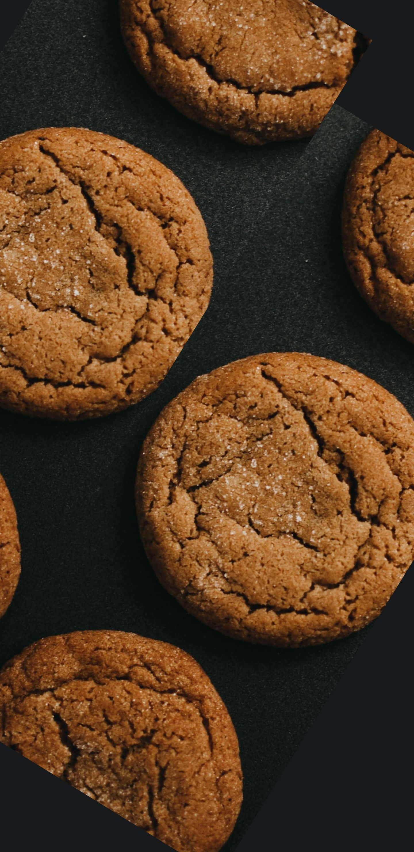 Pixel 3xl Cookies 桌布 壁紙 — 金黃色的紅糖餅乾，頂部有裂紋，閃爍的糖晶體，放在深色啞光表面上。