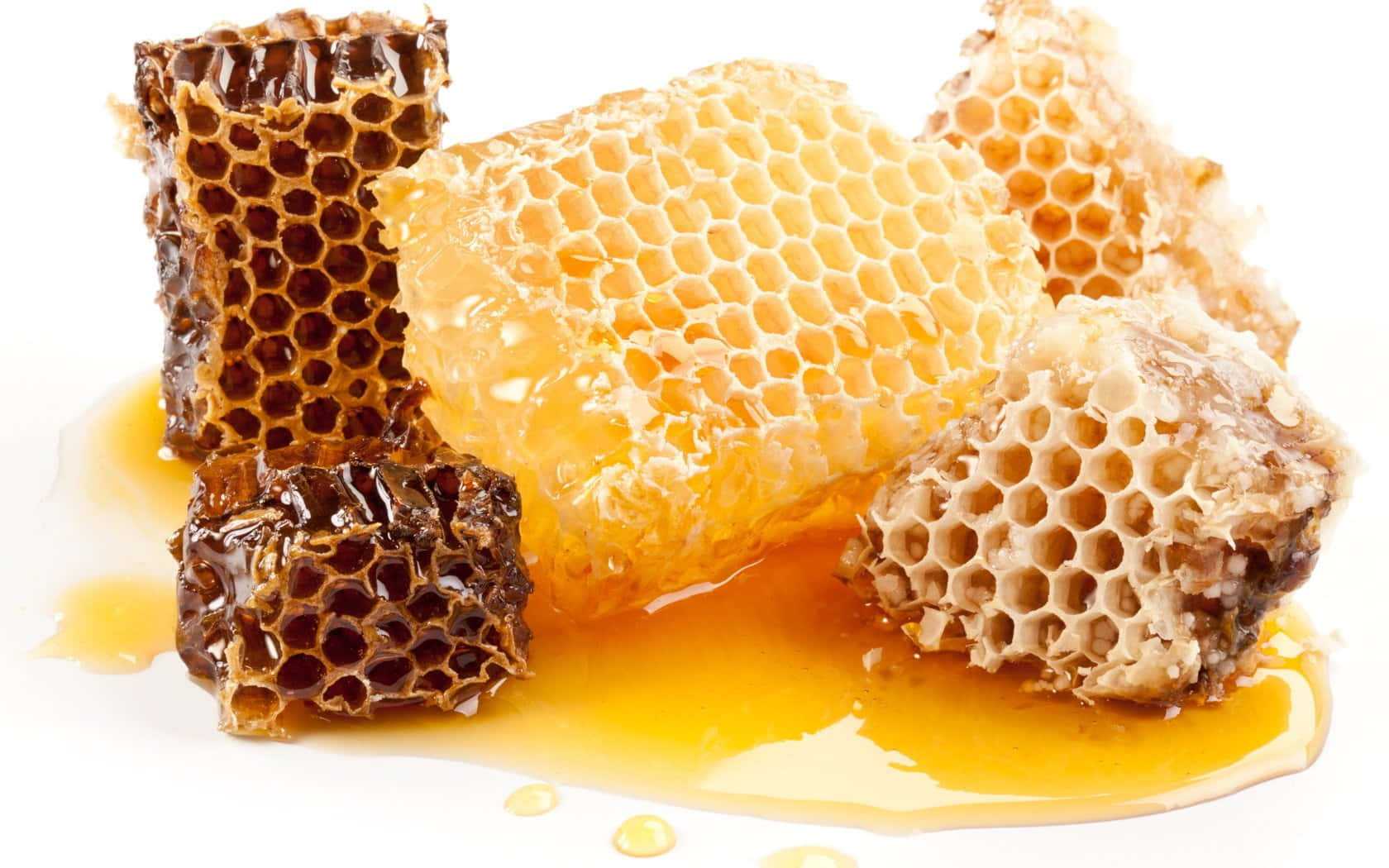 honey 桌布 壁紙 — 金黃色的蜂蜜從豐富的琥珀色蜂巢塊上滴落，背景是純白色。