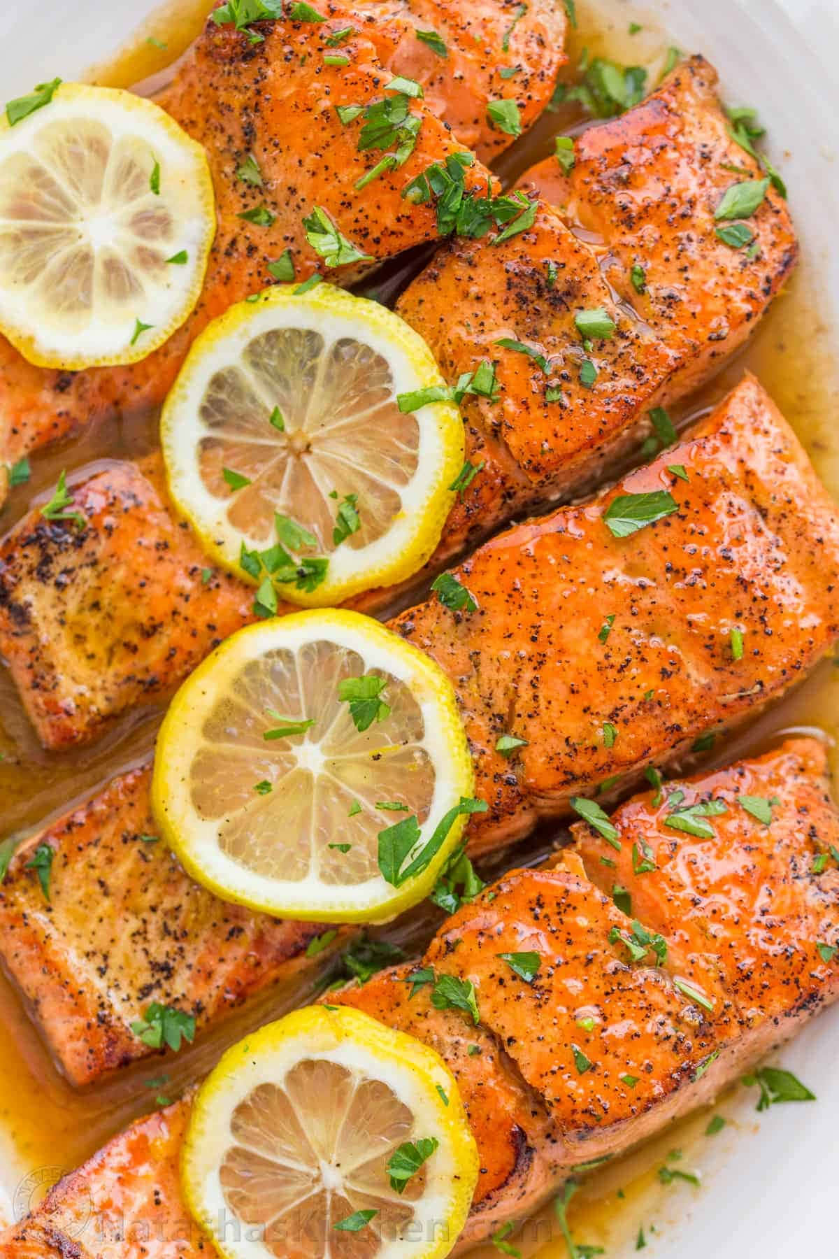 Salmon 桌布 壁紙 — 金黃色的香煎鮭魚排閃爍著醬汁，上面放有檸檬片和新鮮歐芹。