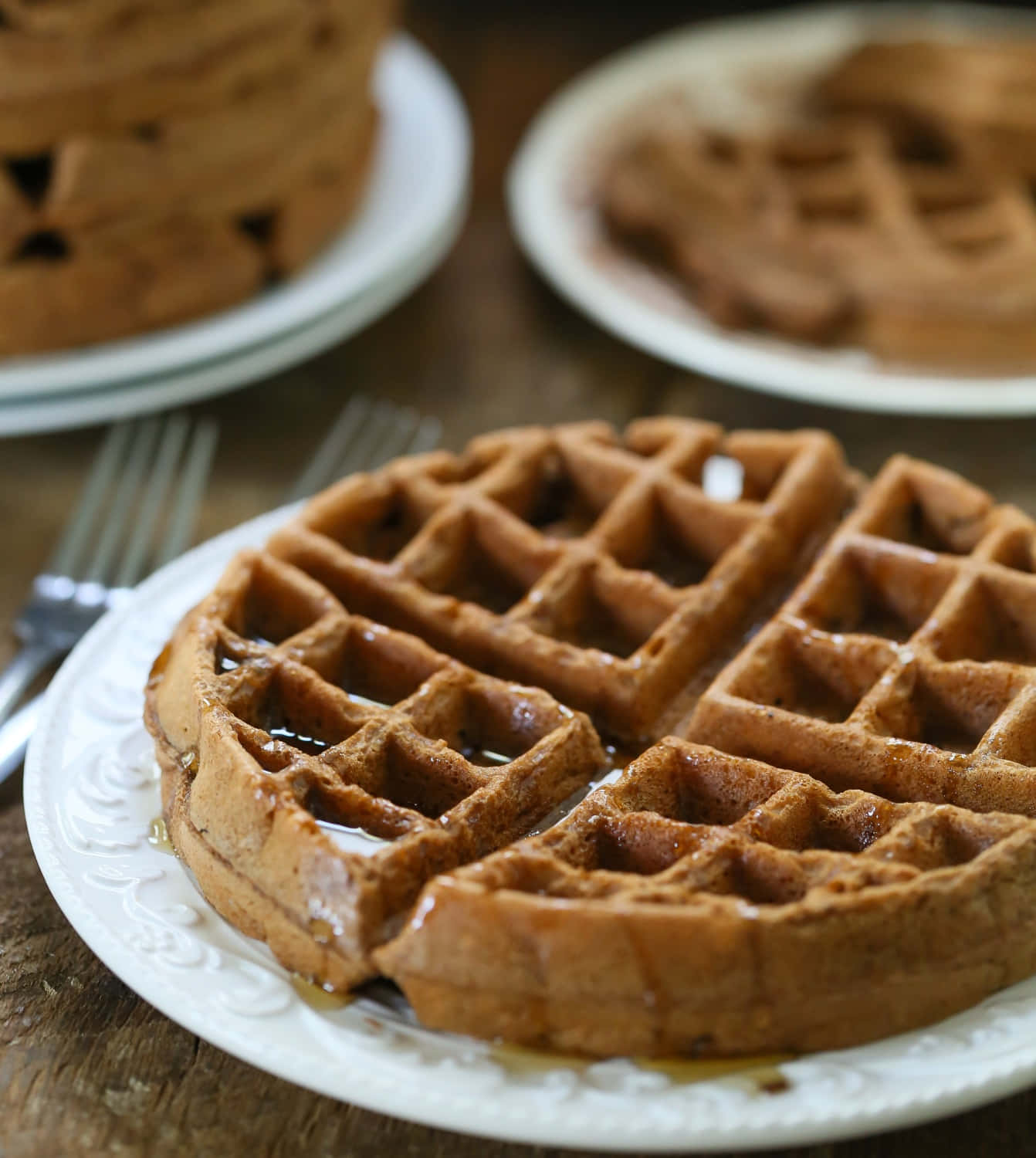 Waffle 桌布 壁紙 — 金黃色的鬆餅在白色盤子上閃閃發光，放在質樸的木桌上。