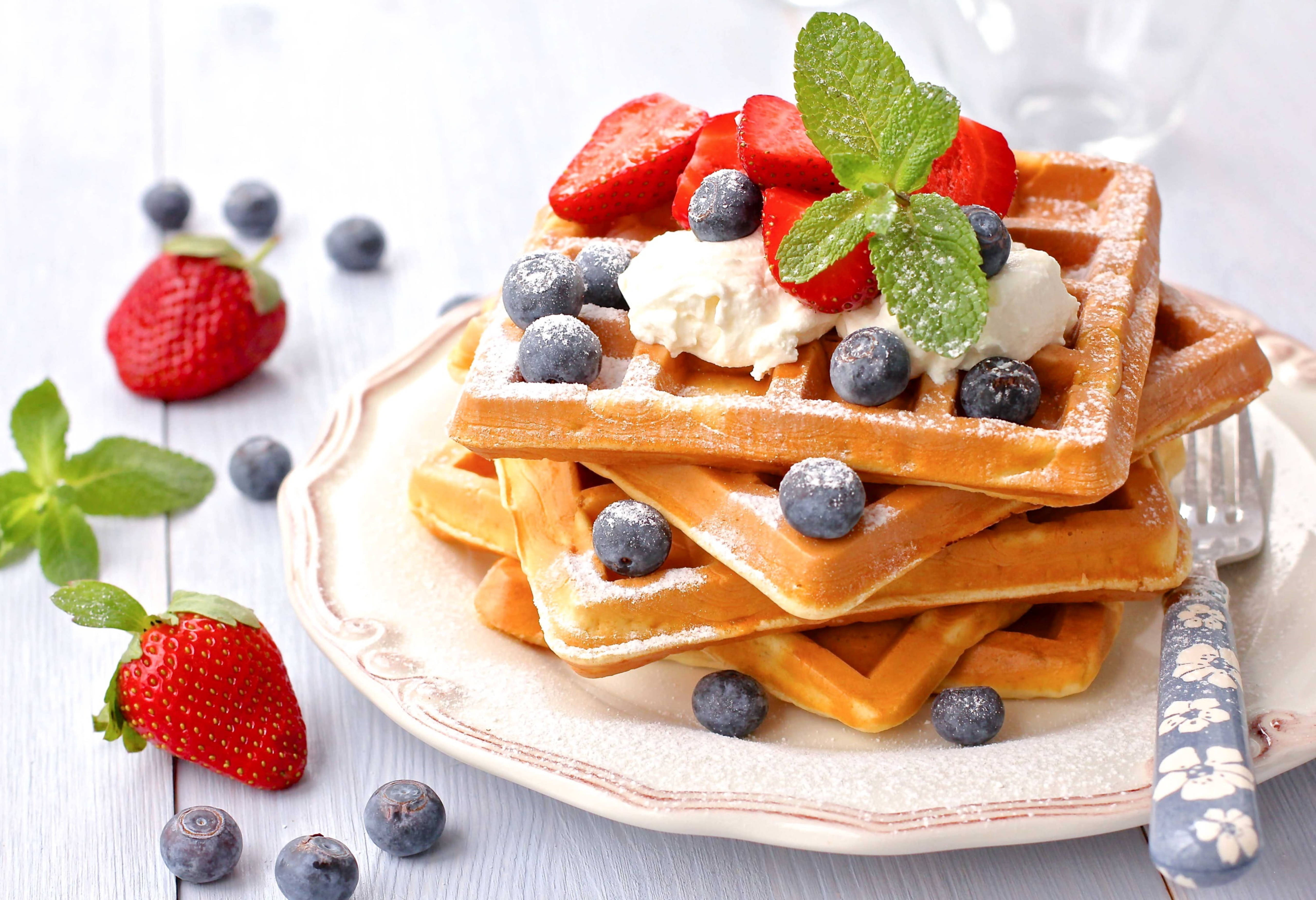Waffle 桌布 壁紙 — 金黃色鬆餅層層疊起，上面放有鮮奶油、草莓、藍莓和薄荷，置於鄉村風格的盤子上。
