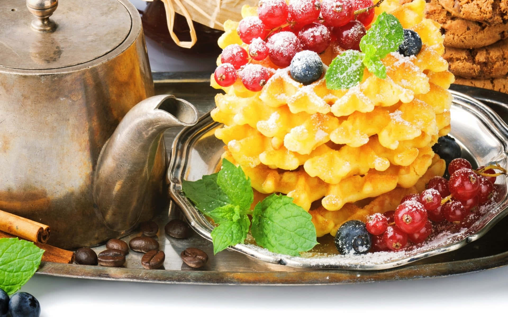 Waffle 桌布 壁紙 — 金黃色鬆餅層層疊起，撒上糖粉，上面放有紅醋栗、藍莓和薄荷葉，置於銀托盤上，旁邊放有一個復古茶壺。