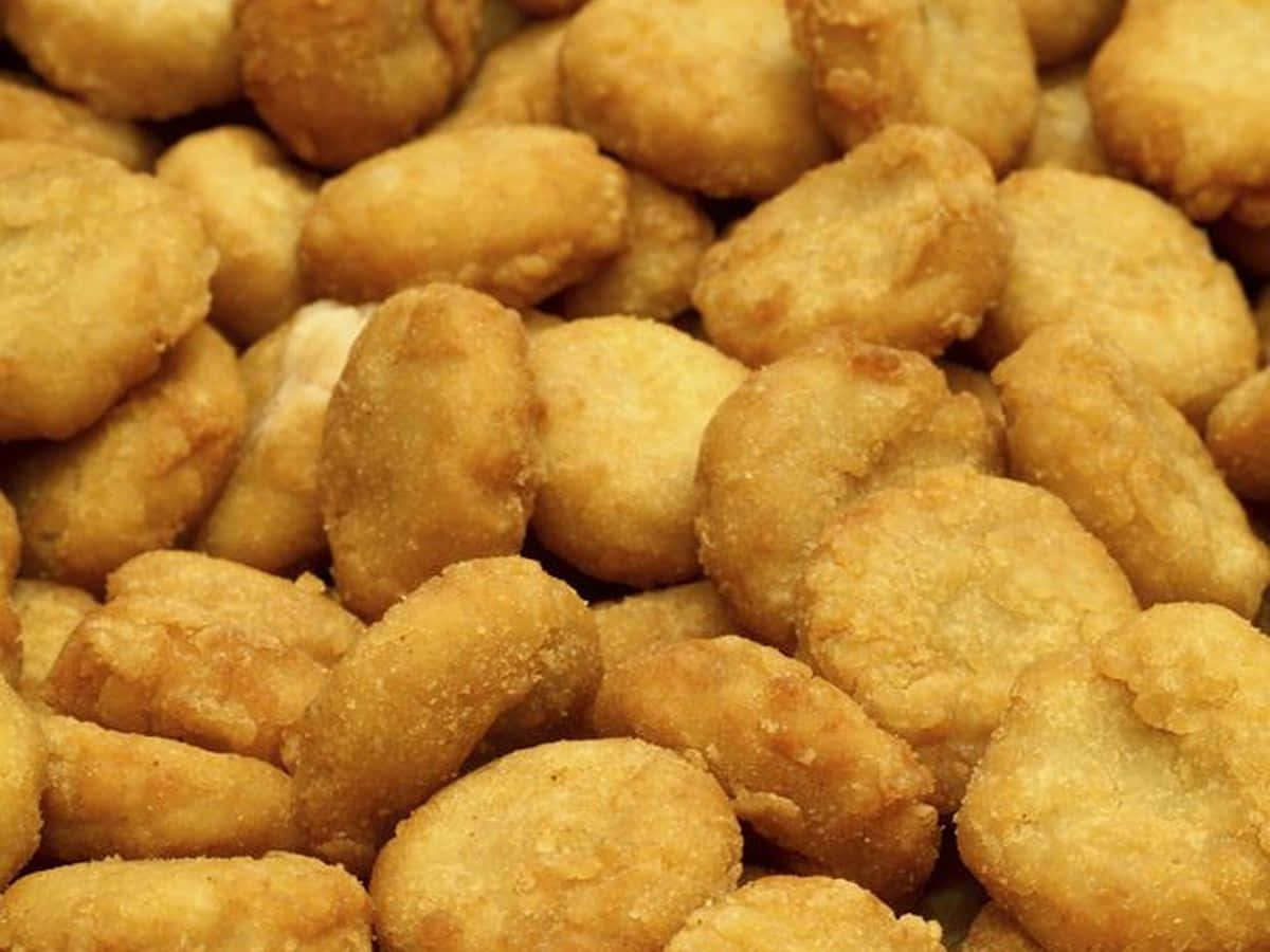 Chicken 桌布 壁紙 — 金黃酥脆炸雞塊的特寫，堆疊在一起，帶有紋理的麵衣。