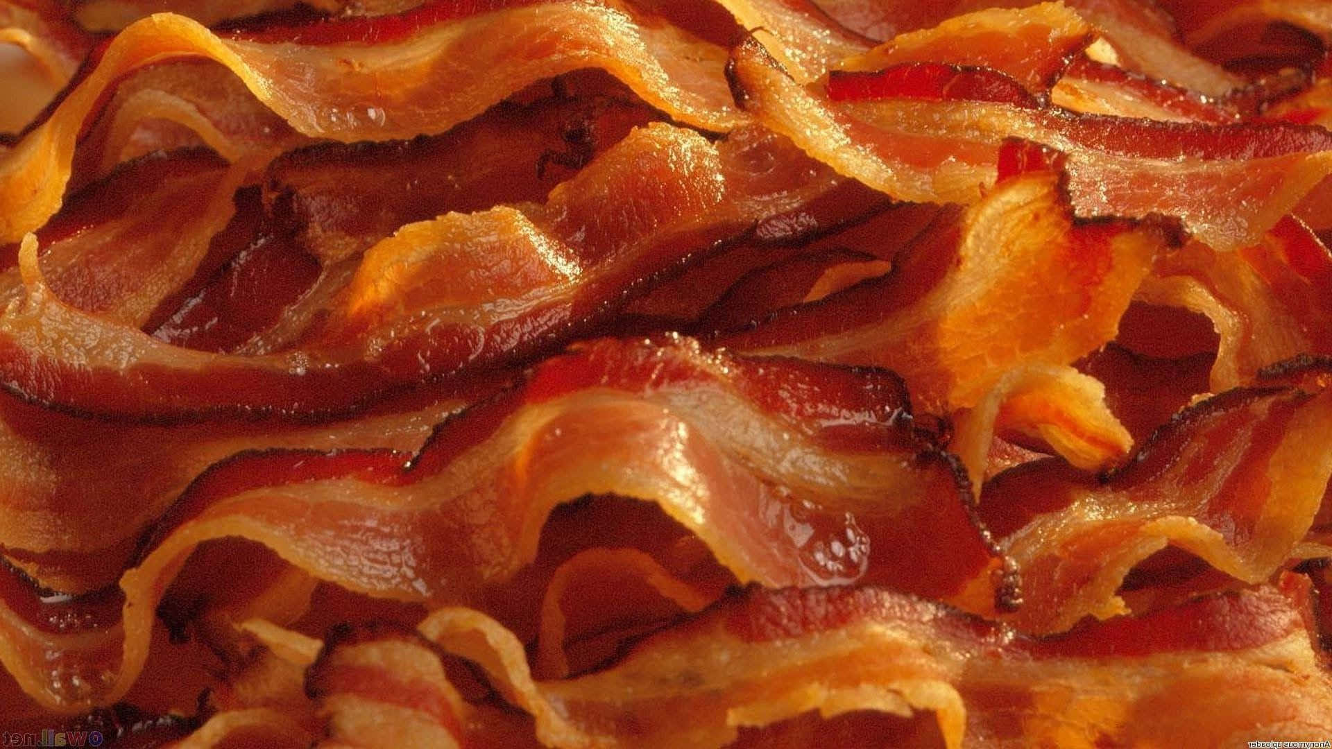 bacon 桌布 壁紙 — 金黃酥脆的培根條在特寫食物鏡頭中閃爍著融化的油脂。