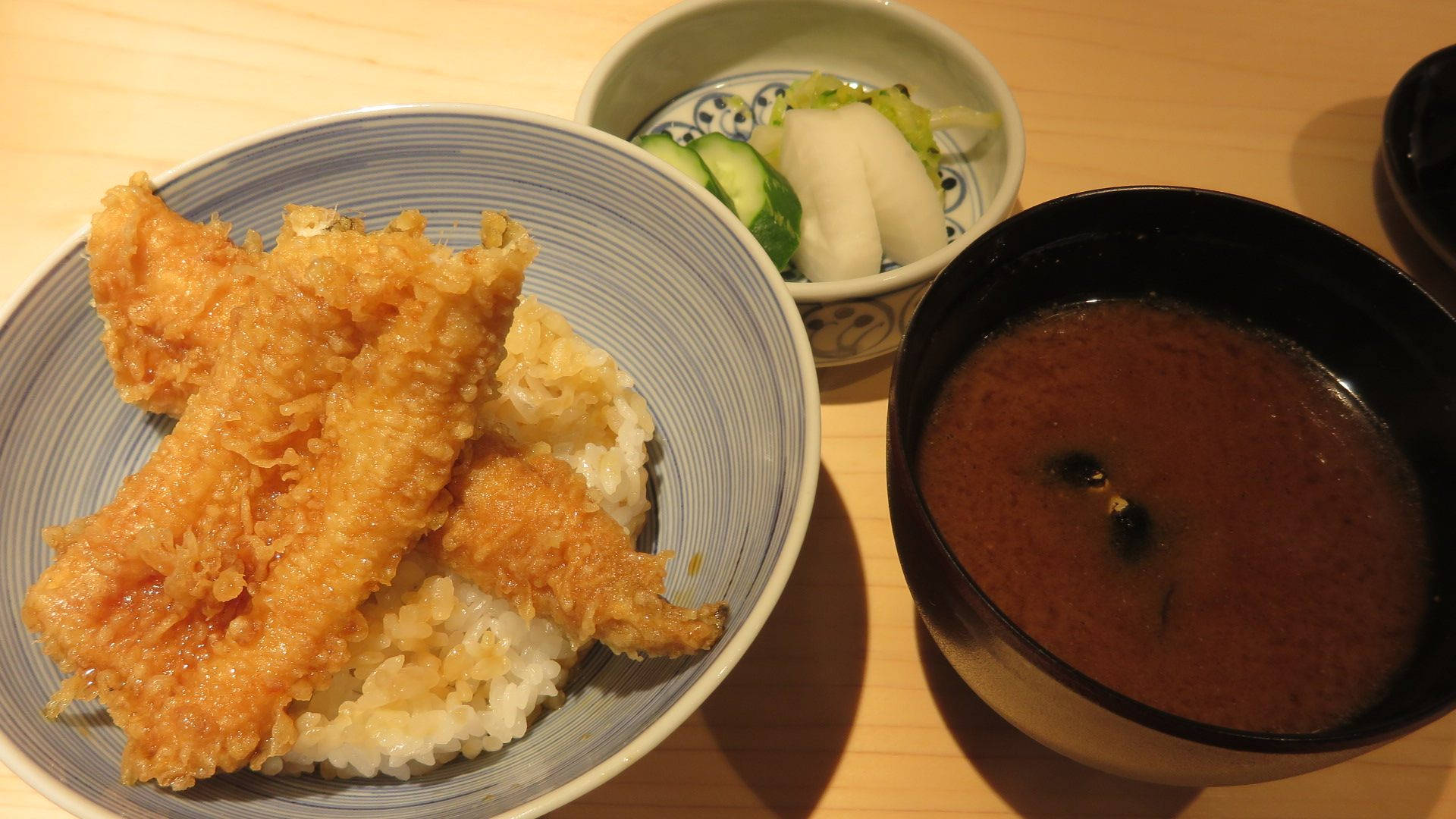 shrimp 桌布 壁紙 — 金黃酥脆的天婦羅放在藍色碗中的蒸飯上，旁邊有味噌湯和醃菜，置於木桌上。