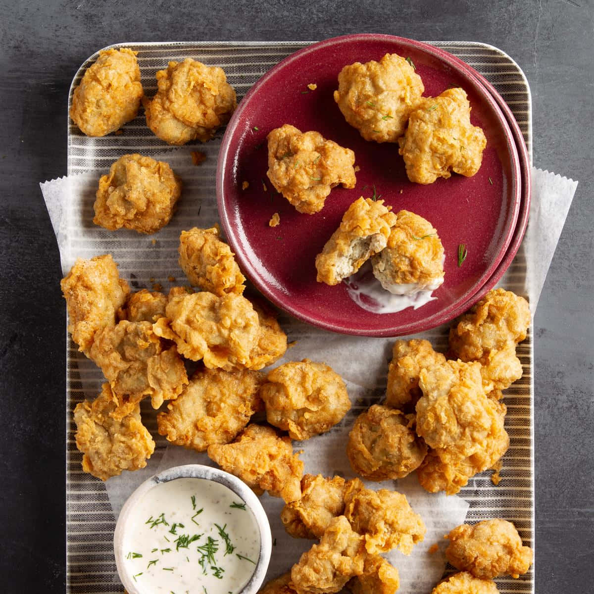 Chicken 桌布 壁紙 — 金黃酥脆的炸花椰菜小朵散落在條紋托盤上，搭配栗色盤子和蒔蘿醬。