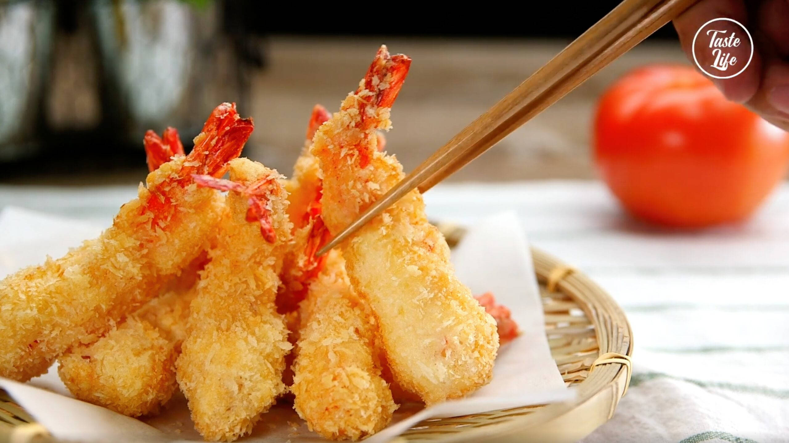 shrimp 桌布 壁紙 — 金黃酥脆的炸蝦（紅尾）被筷子從鋪有紙的編織籃中夾起。