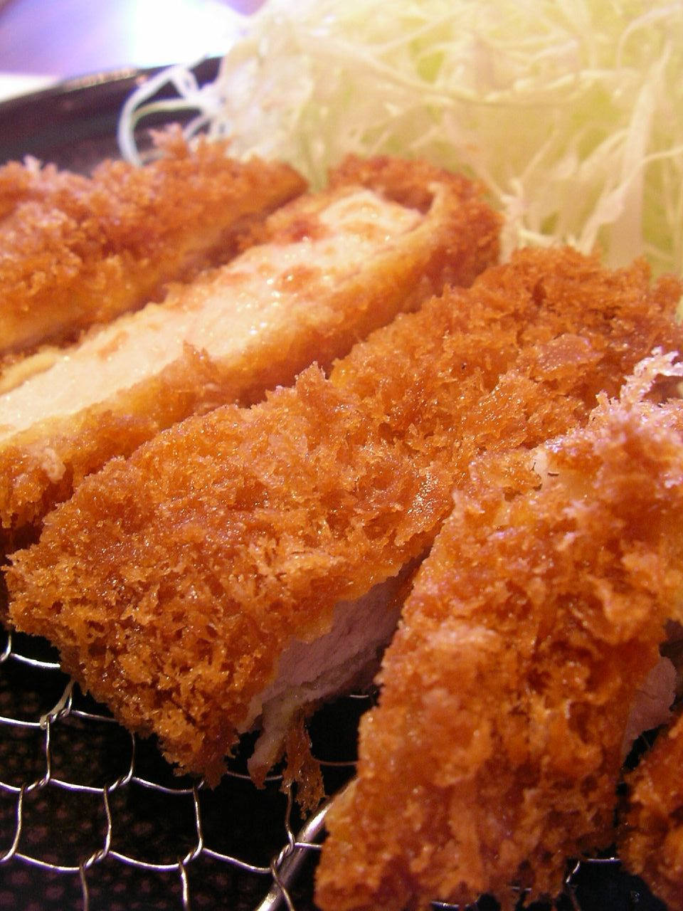 Food Photography 桌布 壁紙 — 金黃酥脆的炸豬排片放在鐵架上，旁邊有高麗菜絲。