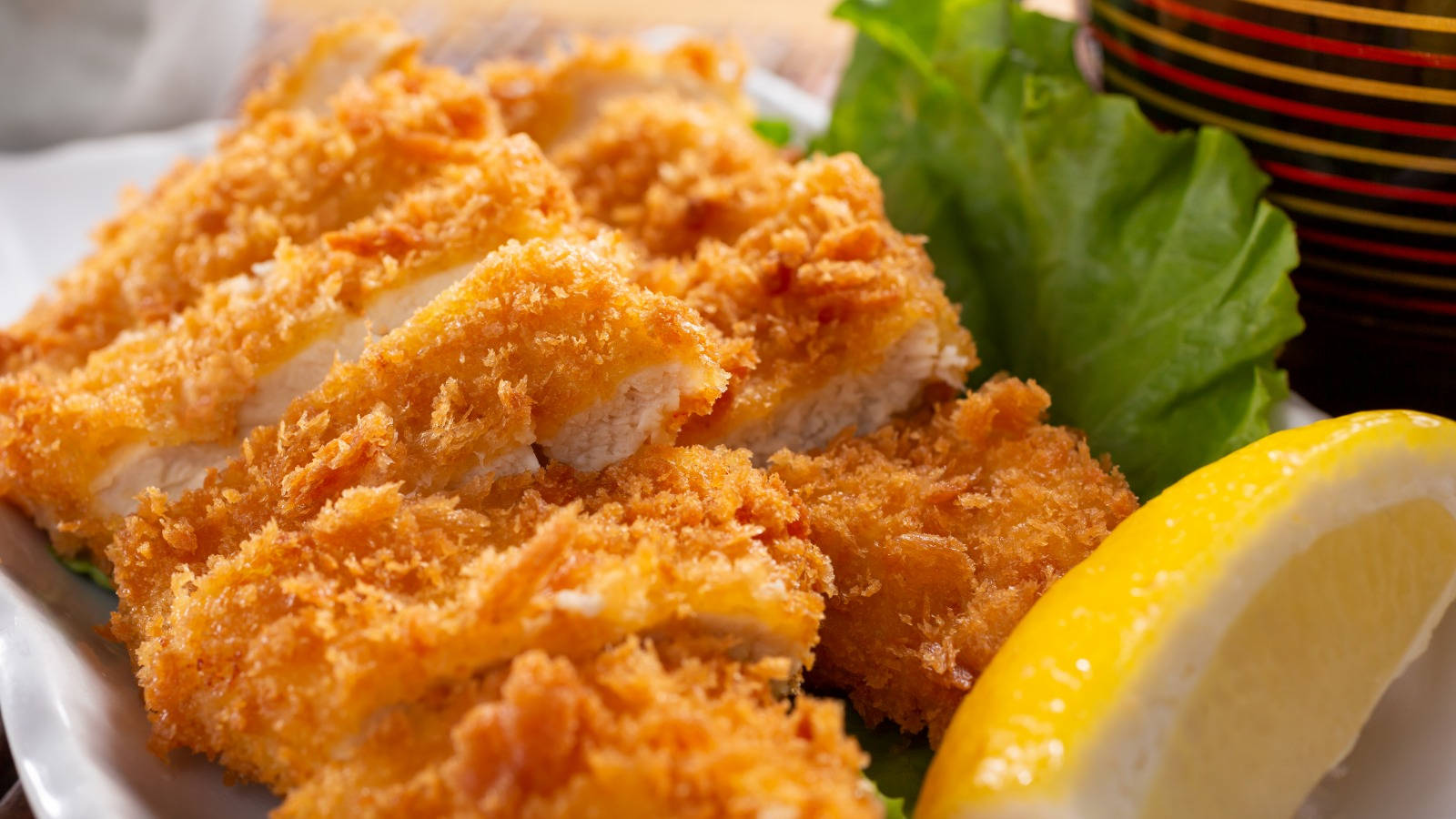 Food Photography 桌布 壁紙 — 金黃酥脆的炸雞排，配上新鮮生菜和明亮的檸檬角。
