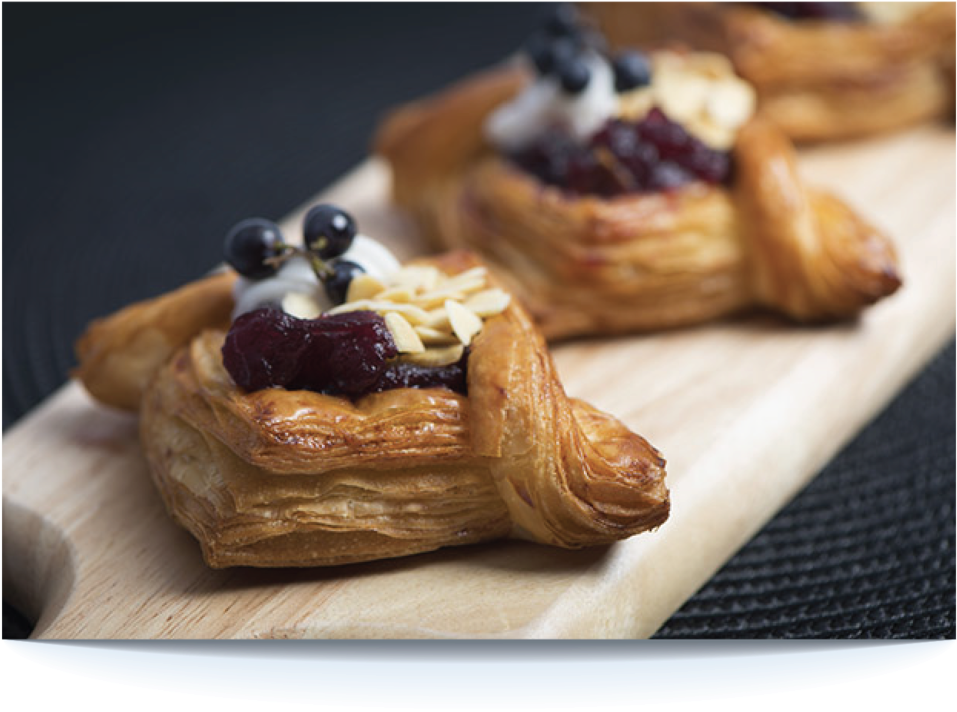 Pastries 桌布 壁紙 — 金黃酥脆的糕點，上面鋪滿莓果奶油和杏仁，放在木板上，背景為深色紋理。