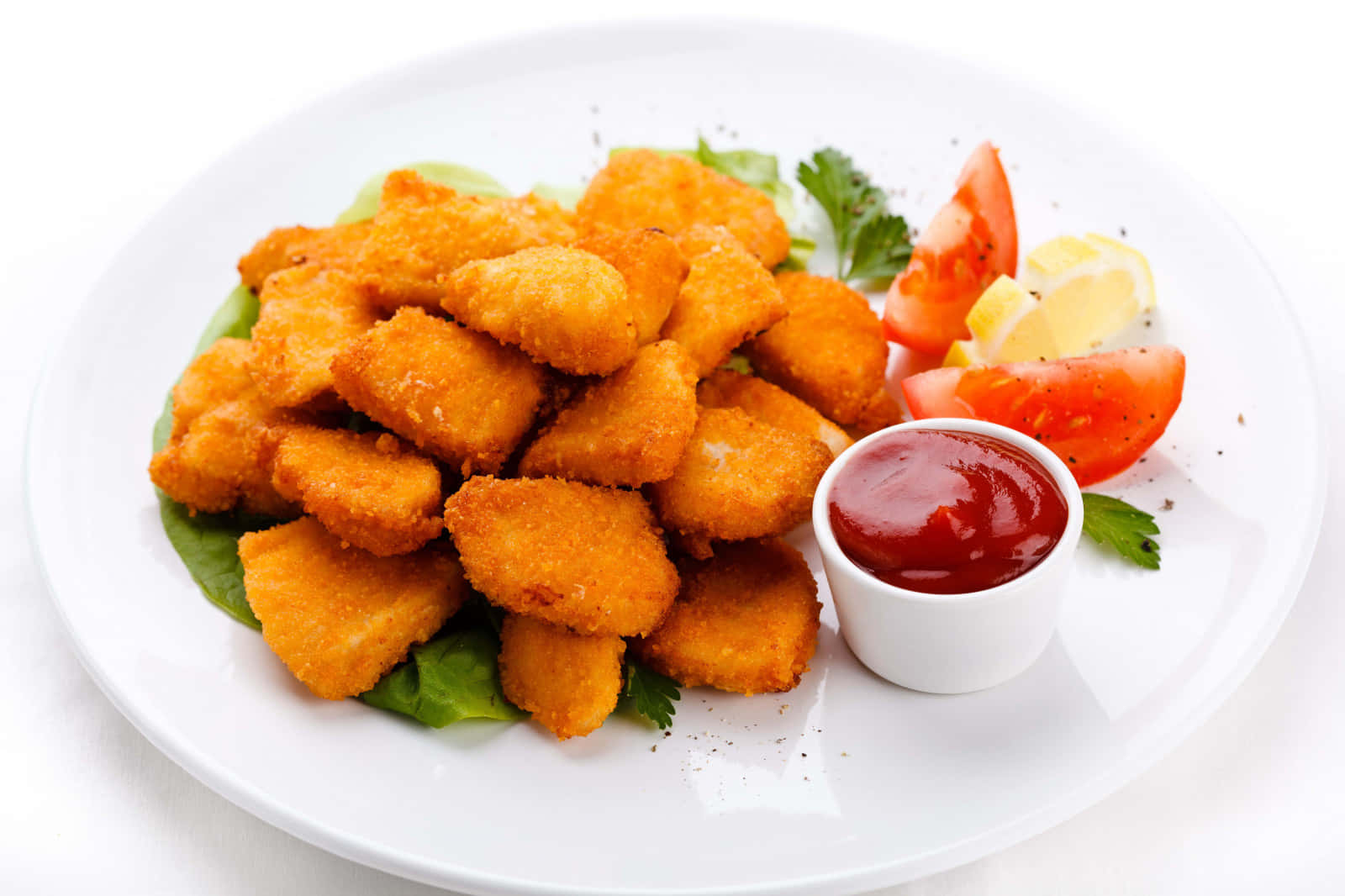 Chicken Nuggets 桌布 壁紙 — 金黃酥脆的雞塊高高堆在白色盤子上，搭配新鮮蔬菜、番茄片、檸檬角以及旁邊的番茄醬。
