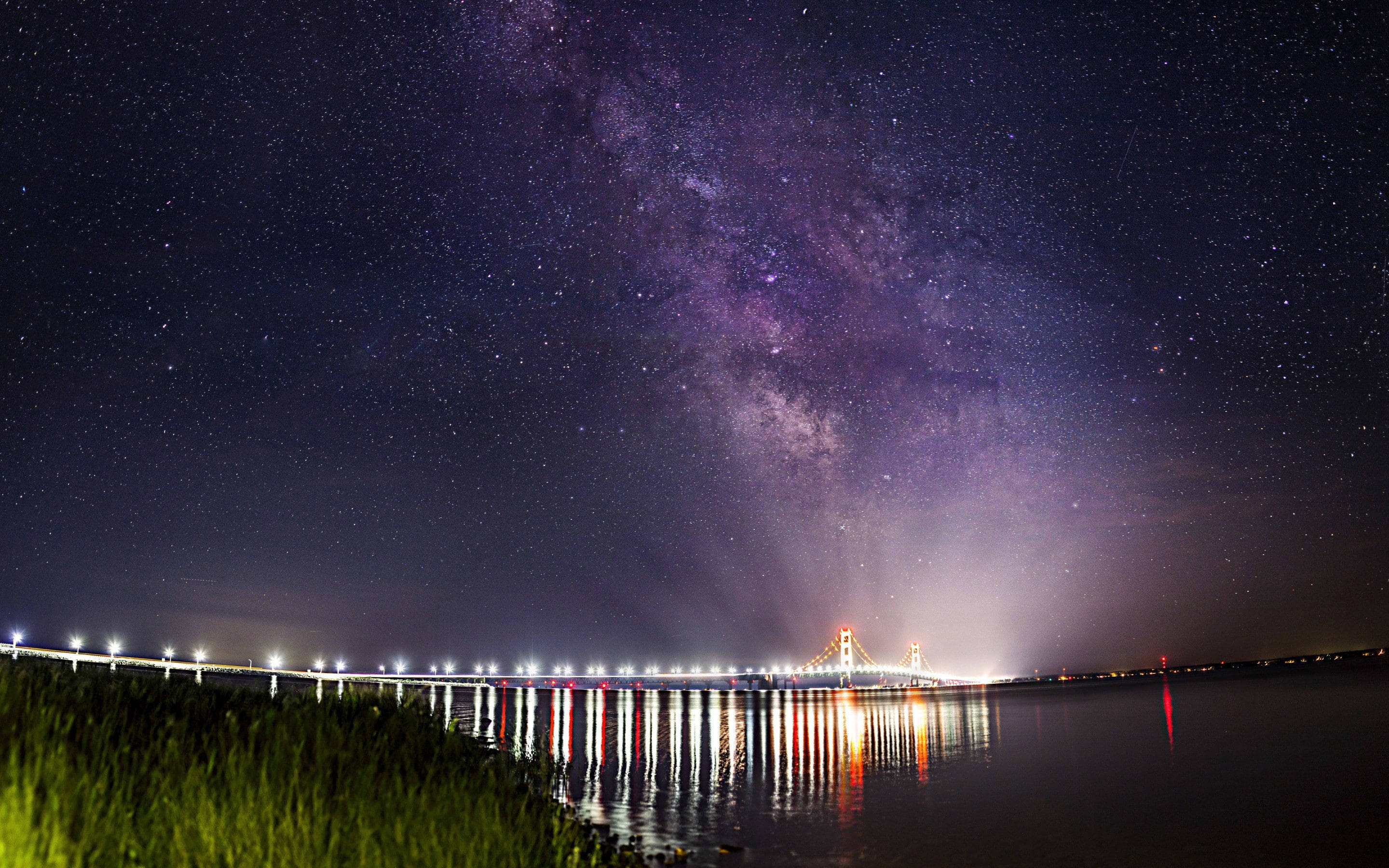 夜空 桌布 壁紙 — 銀河在星空下平靜的水面上拱起一座發光的橋樑，倒映在水中。